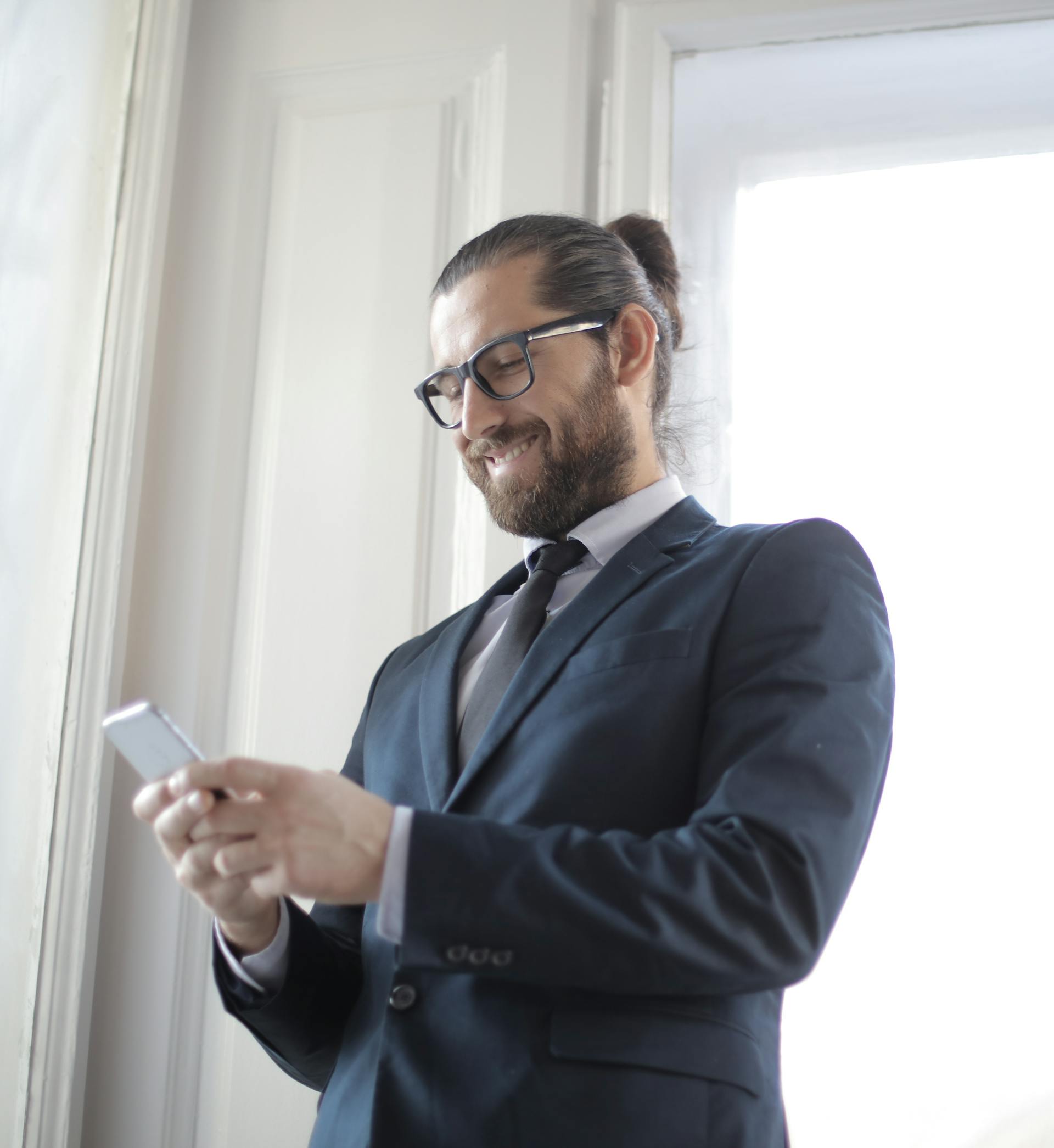 Un uomo che sorride al suo telefono | Fonte: Pexels