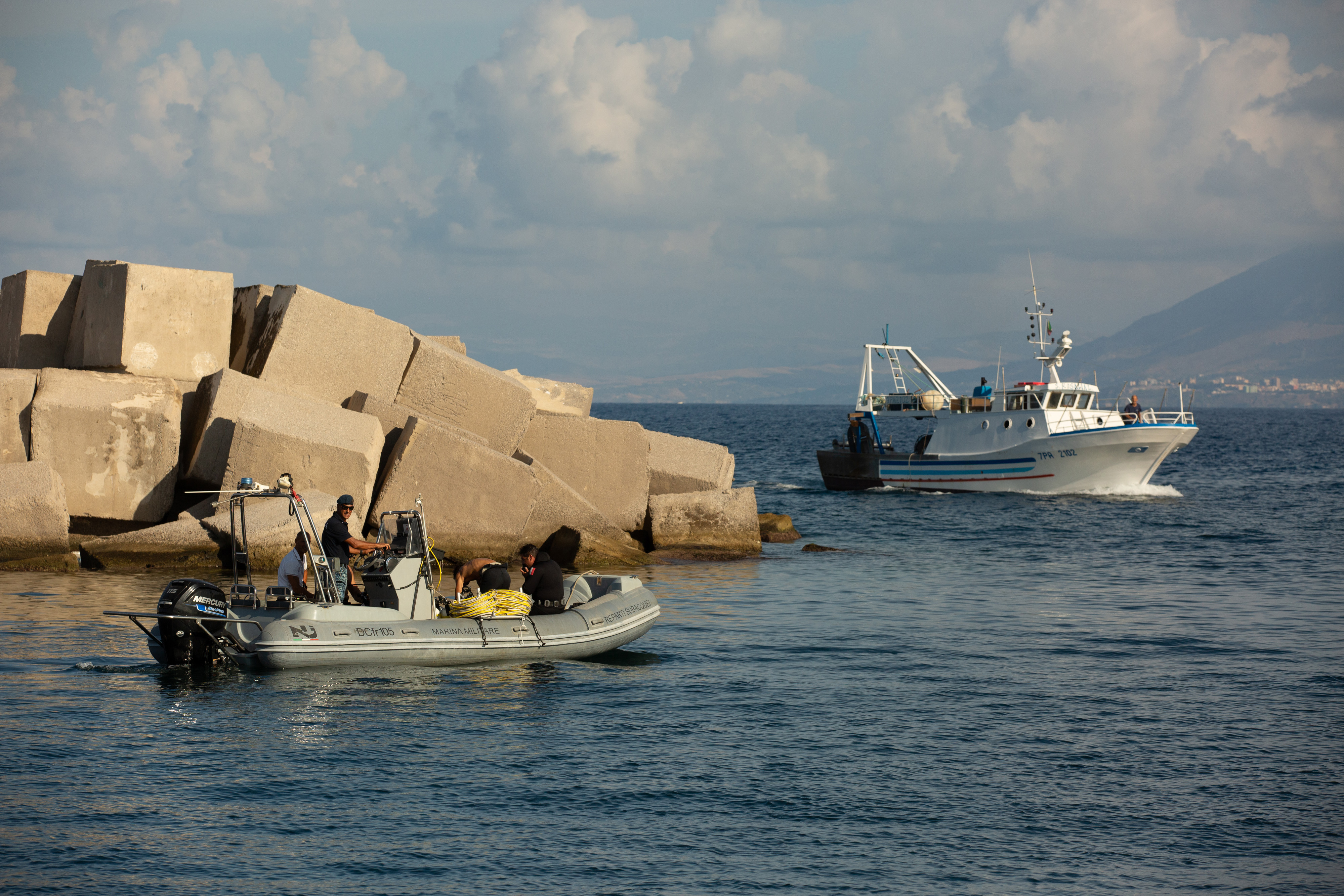 Un barco pesquero pasa junto a una costilla con buzos a bordo durante las operaciones de búsqueda del yate de lujo Bayesian, frente a la costa de Porticello, Italia, el 22 de agosto de 2024 | Fuente: Getty Images