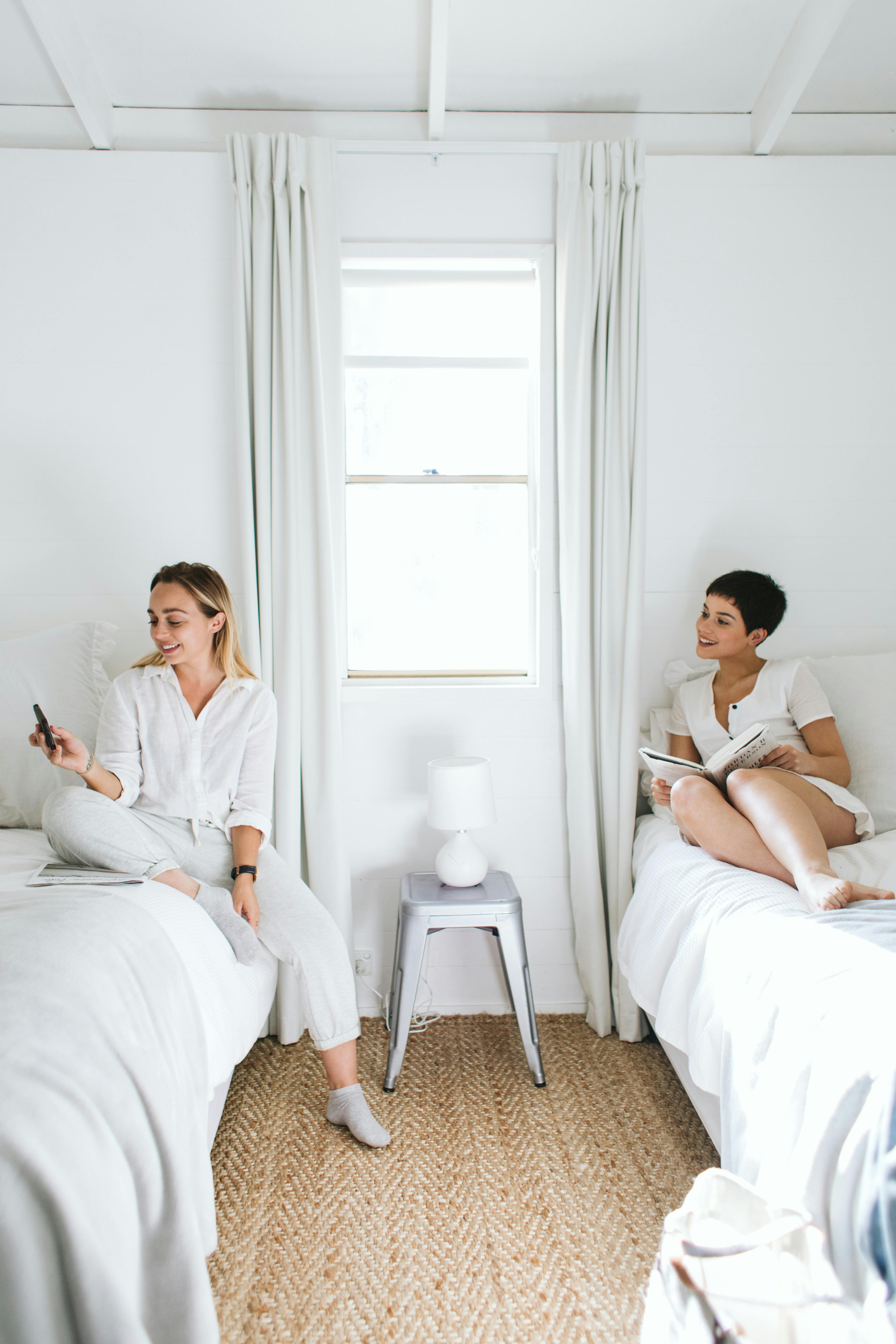 Dos mujeres sentadas en camas individuales | Foto: Pexels