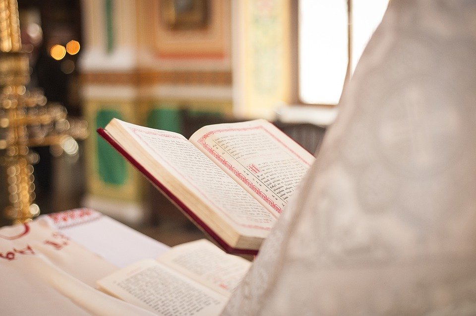 Sacerdote celebrando una misa con la Biblia en su mano. | Imagen: Pixabay