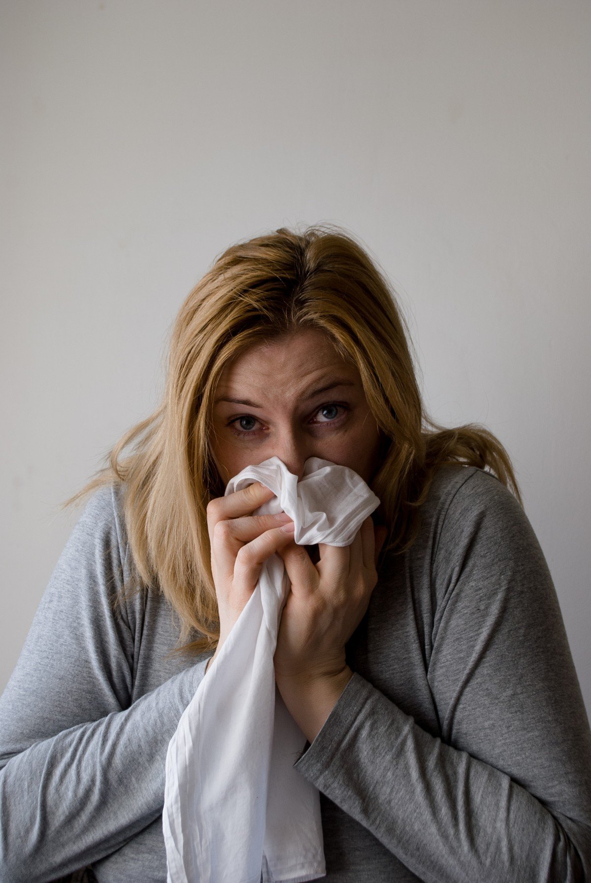 Mujer tosiendo con pañuelo sobre su rostro. | Imagen: PxHere