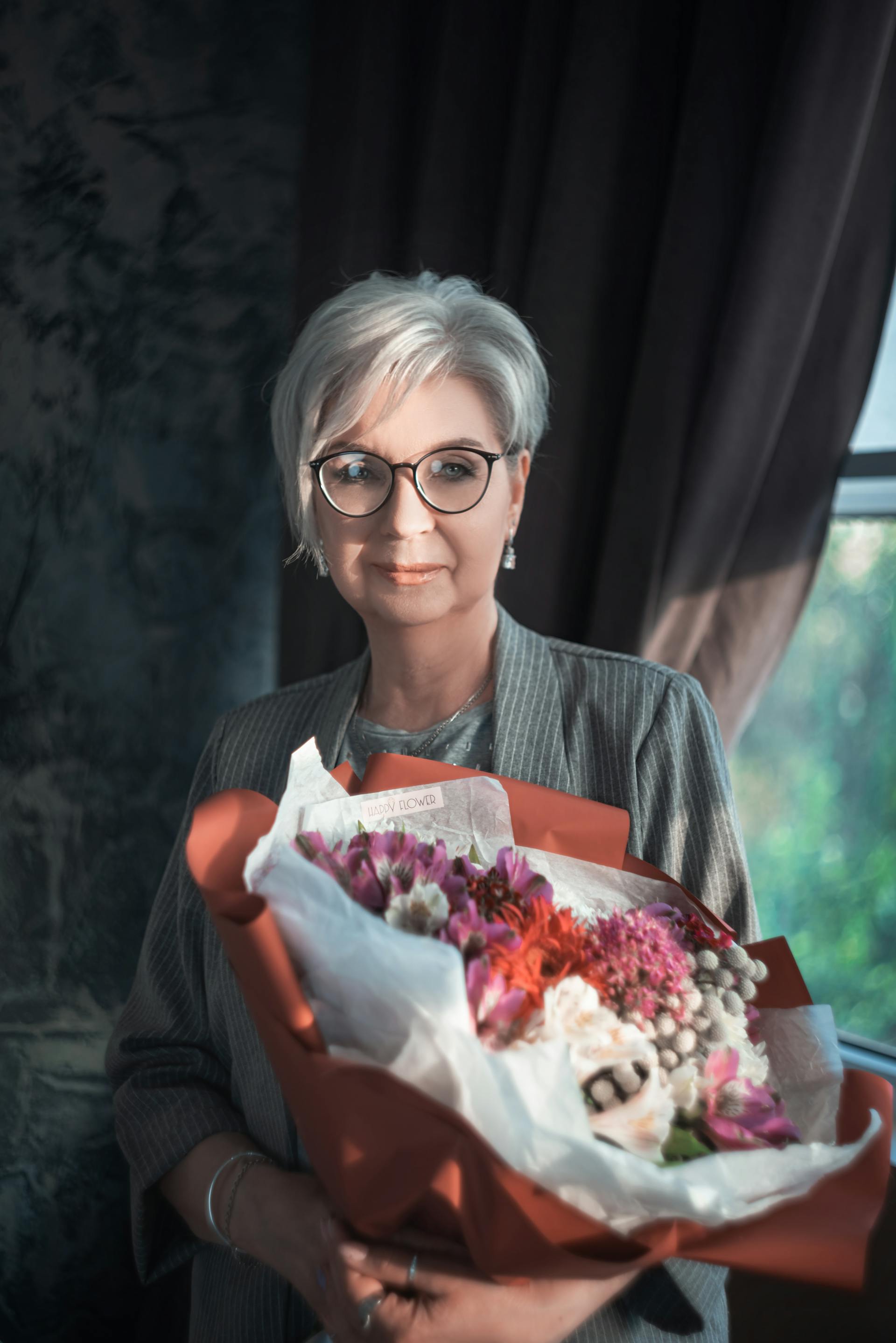 Una mujer sonriente con un ramo de flores | Fuente: Pexels