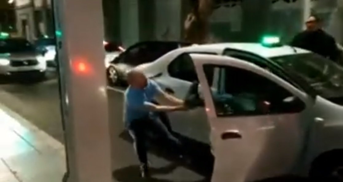 El taxista enfurecido intenta sacar del vehículo al pasajero de manera violenta. Fuente: Facebook / Max Gomez 