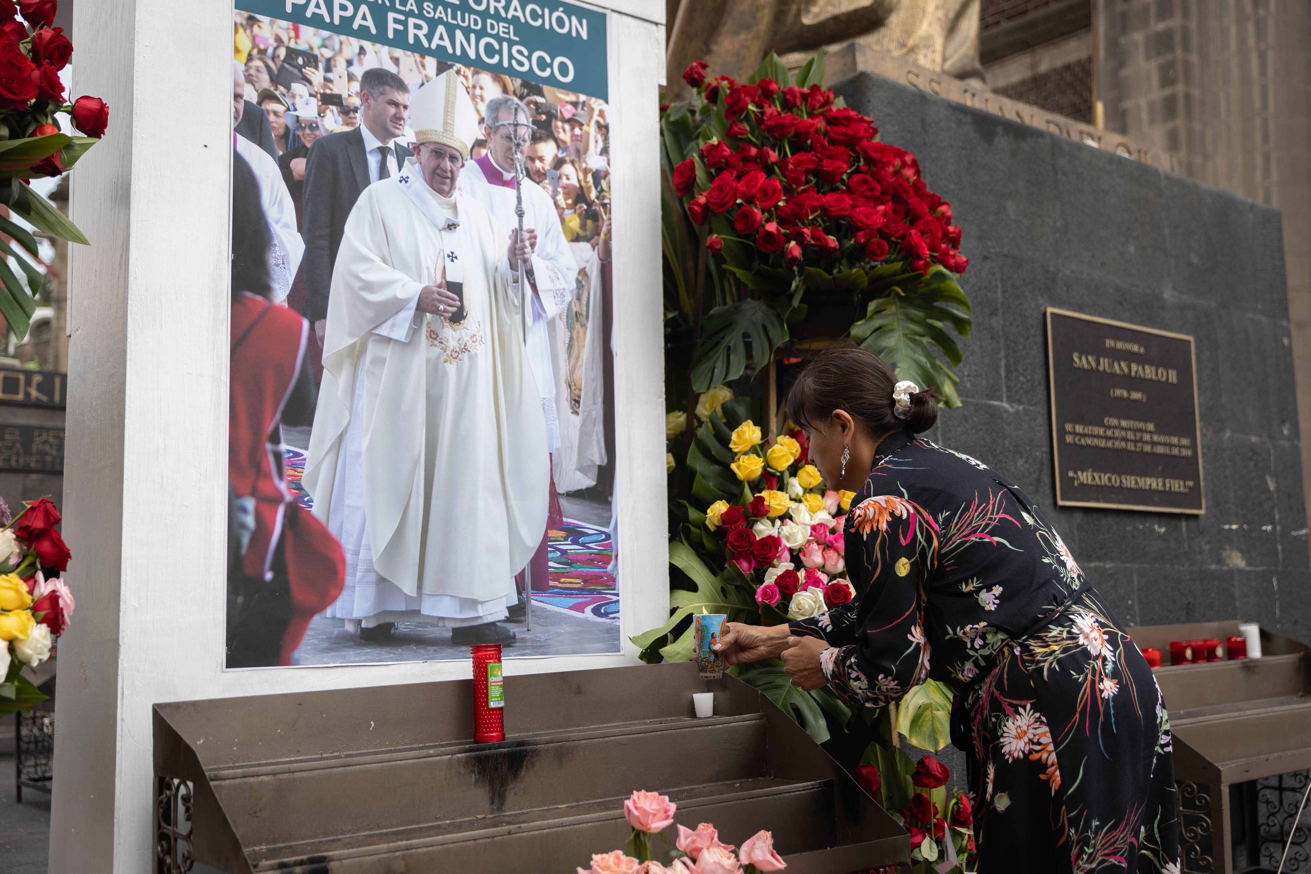 Una mujer coloca una vela frente a una imagen del Papa Francisco fuera de la Basílica de Guadalupe, en Ciudad de México, México, el 23 de febrero de 2025. | Fuente: Getty Images