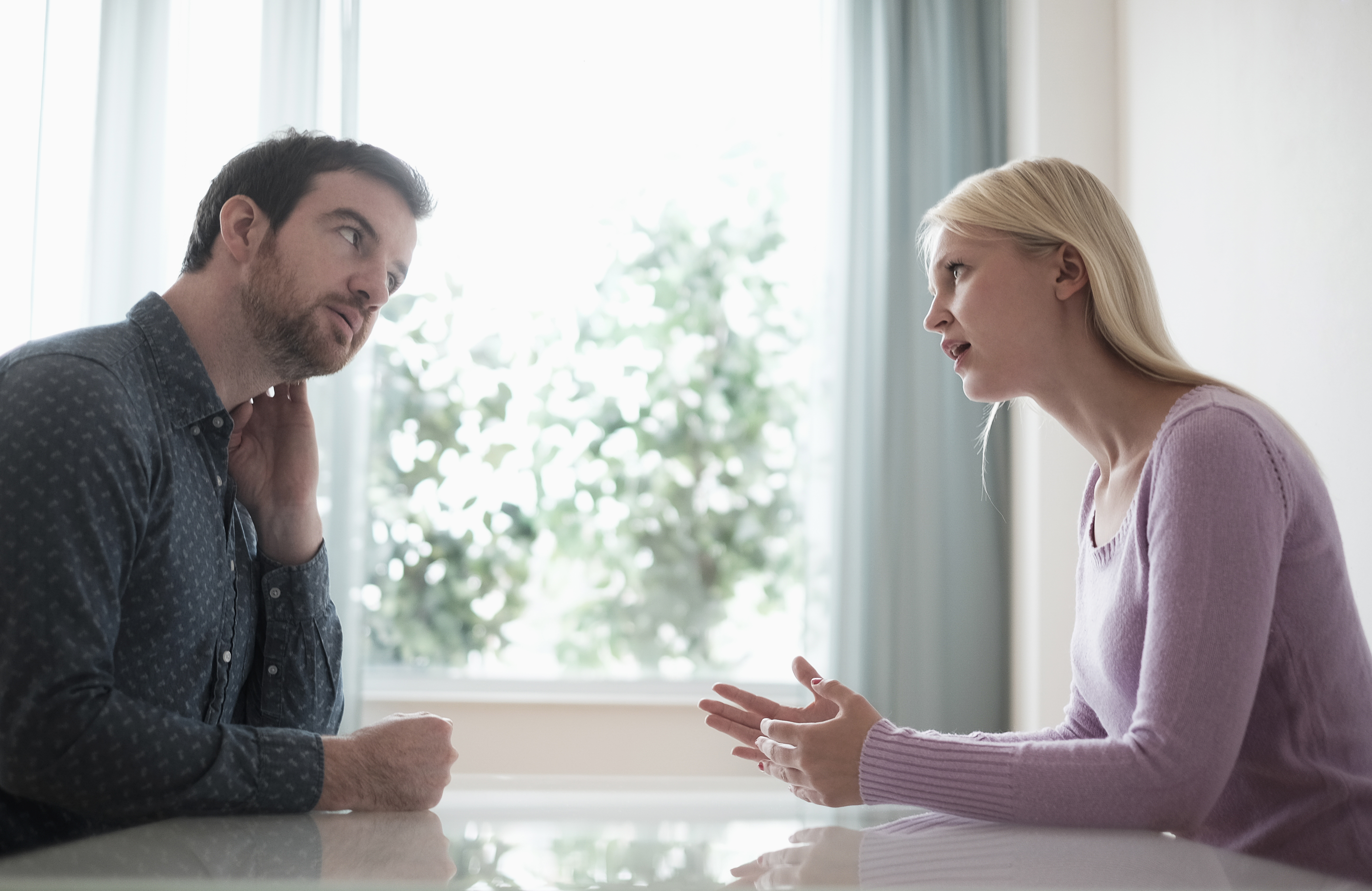 Hombre y mujer hablando en una mesa | Foto: Getty Images