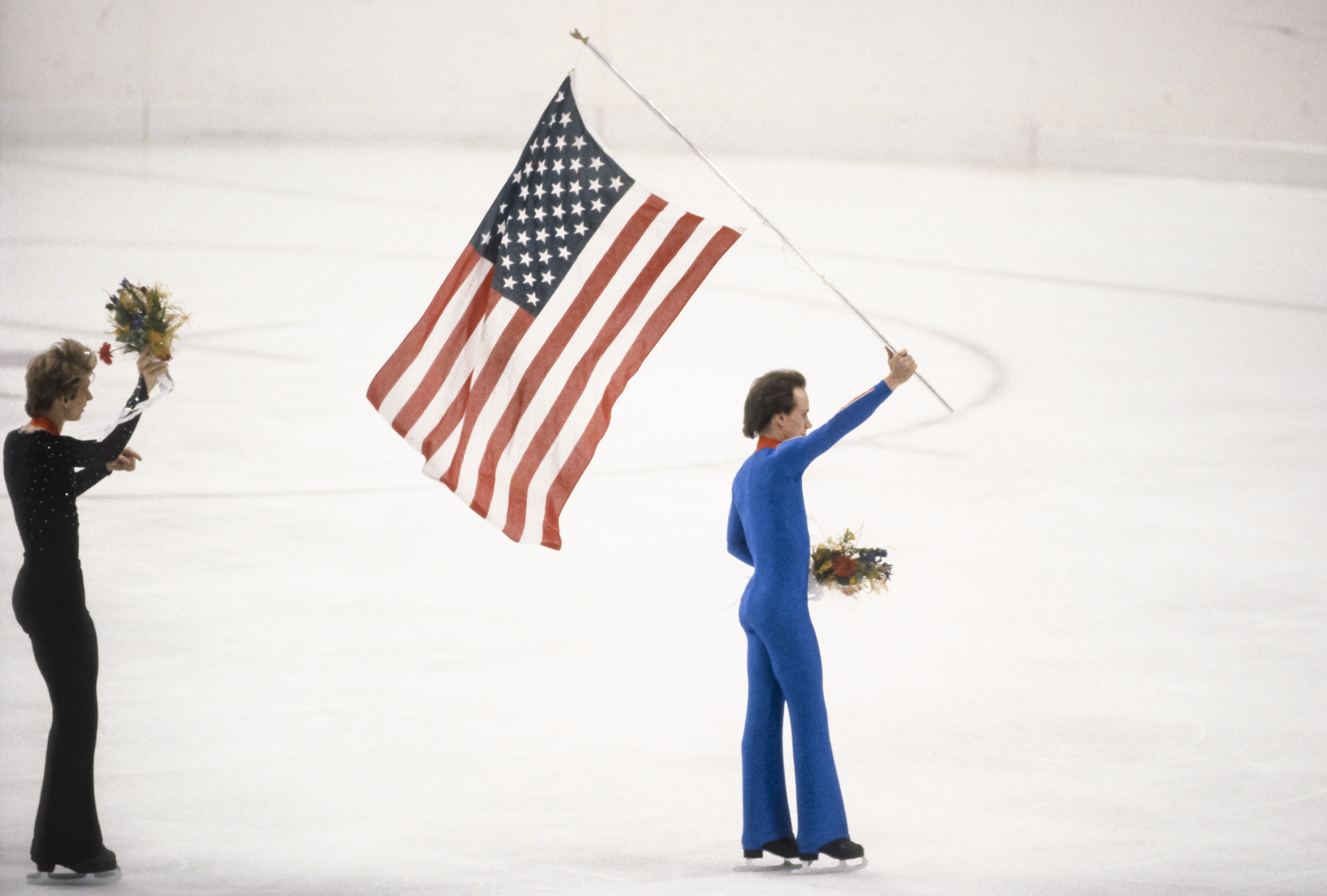 Scott Hamilton (EEUU) patina con la bandera de EEUU tras la ceremonia de entrega de medallas de la competición individual masculina de los Juegos Olímpicos de Invierno de 1984 en Sarajevo, Yugoslavia, el 16 de febrero de 1984 | Foto: Getty Images
