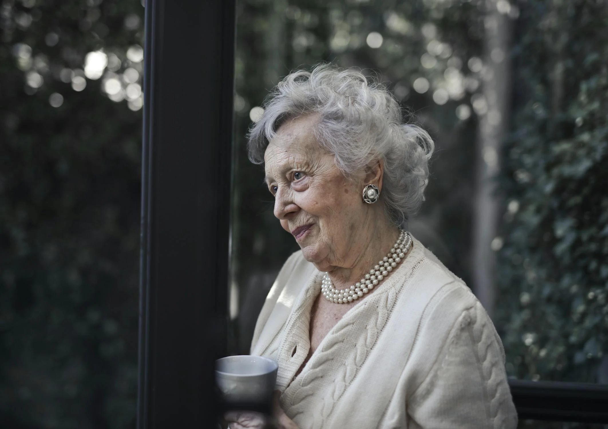 Una mujer con una taza de café en su patio | Fuente: Pexels