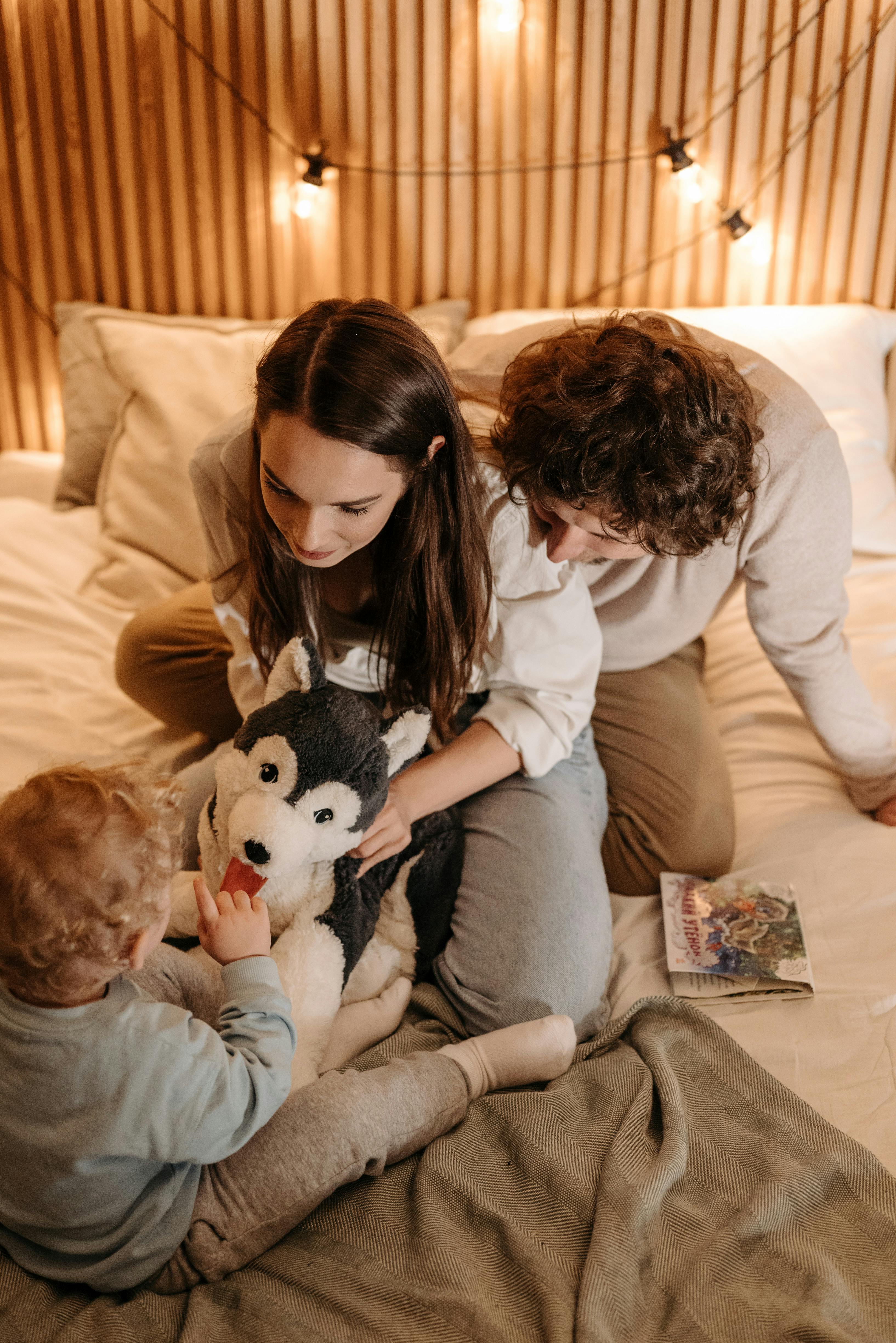 Una pareja feliz jugando con un niño | Fuente: Pexels