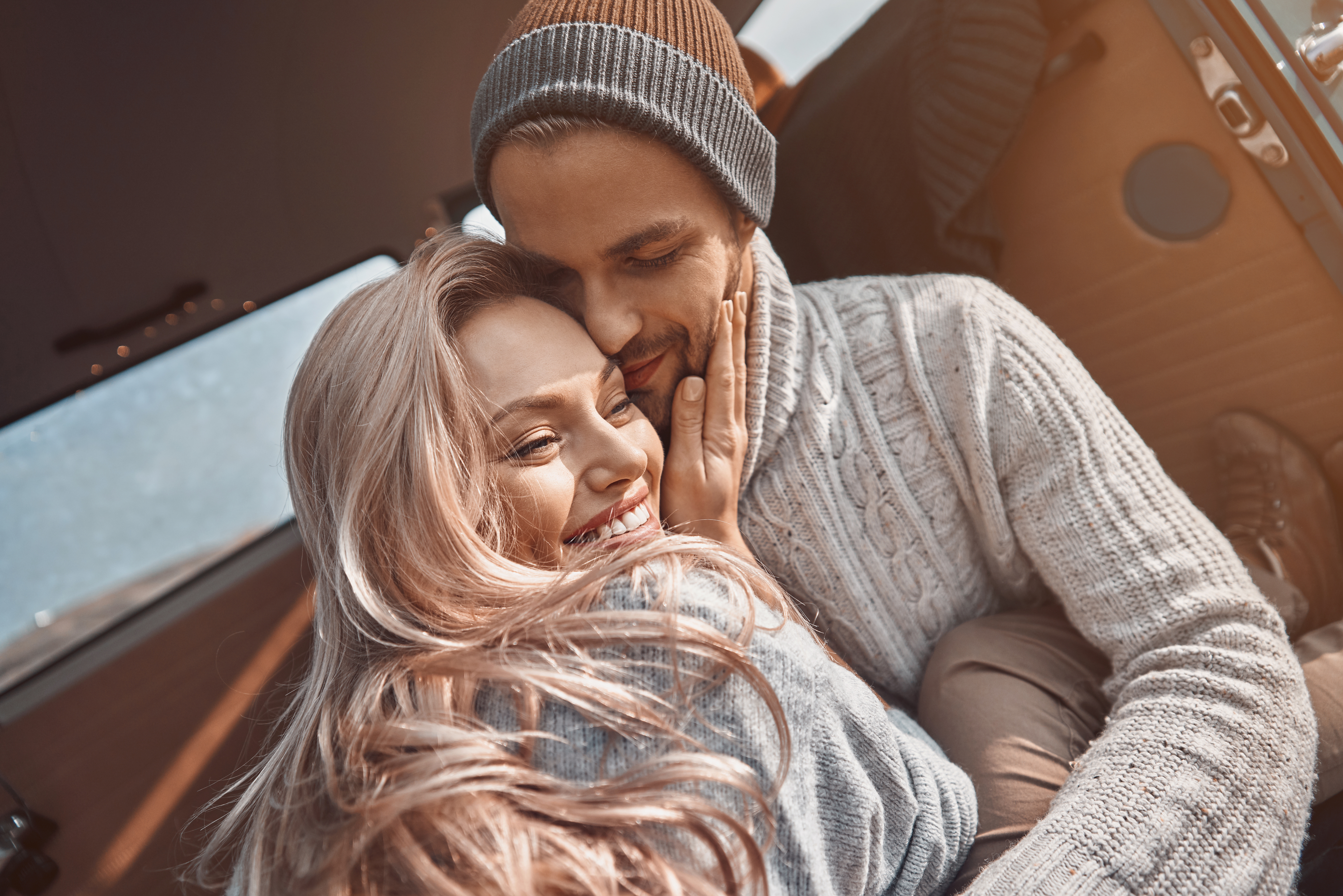 Pareja de enamorados abrazándose en su monovolumen | Foto: Shutterstock