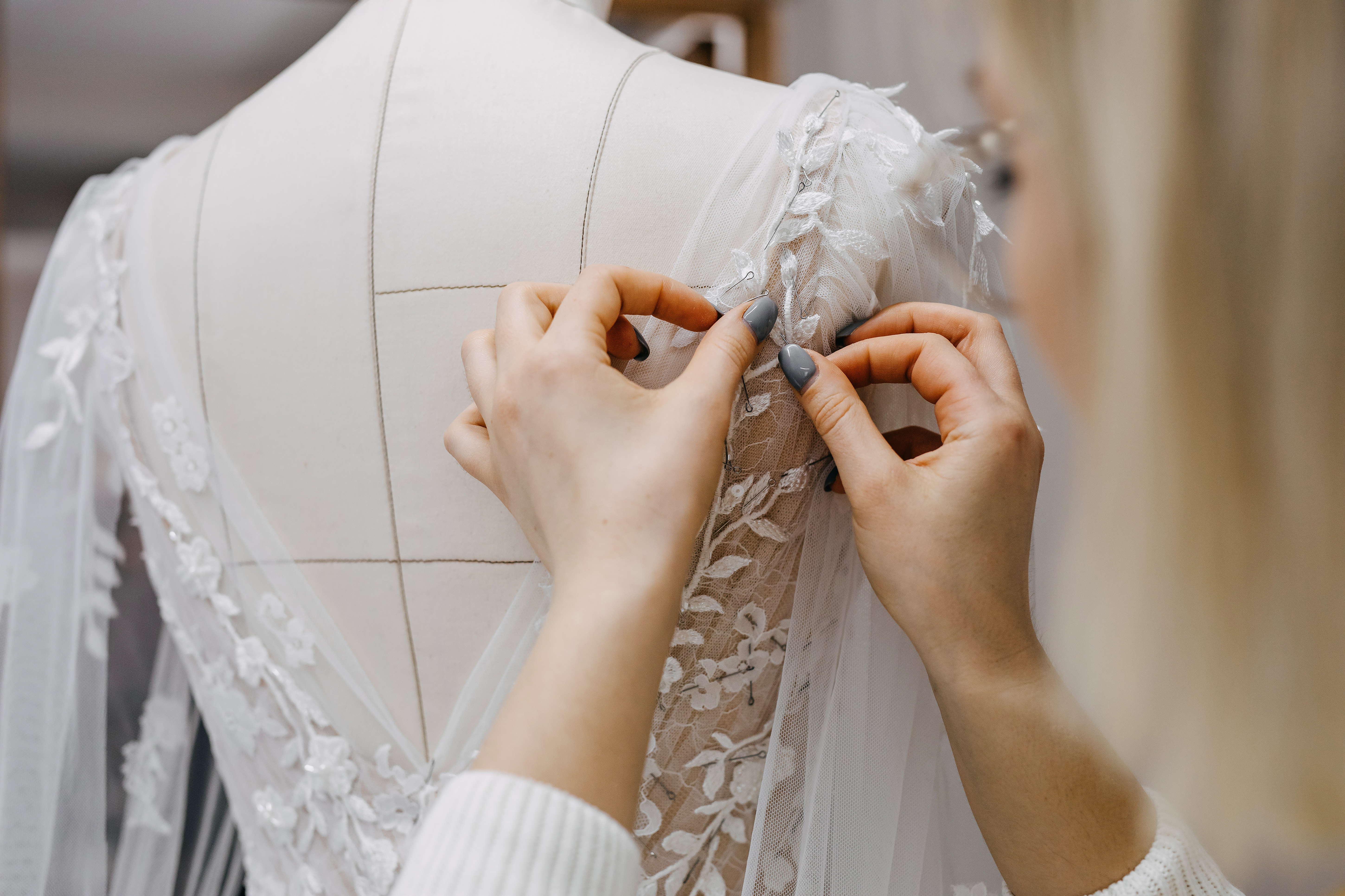 Una mujer cosiendo un vestido de novia. | Foto: Shutterstock
