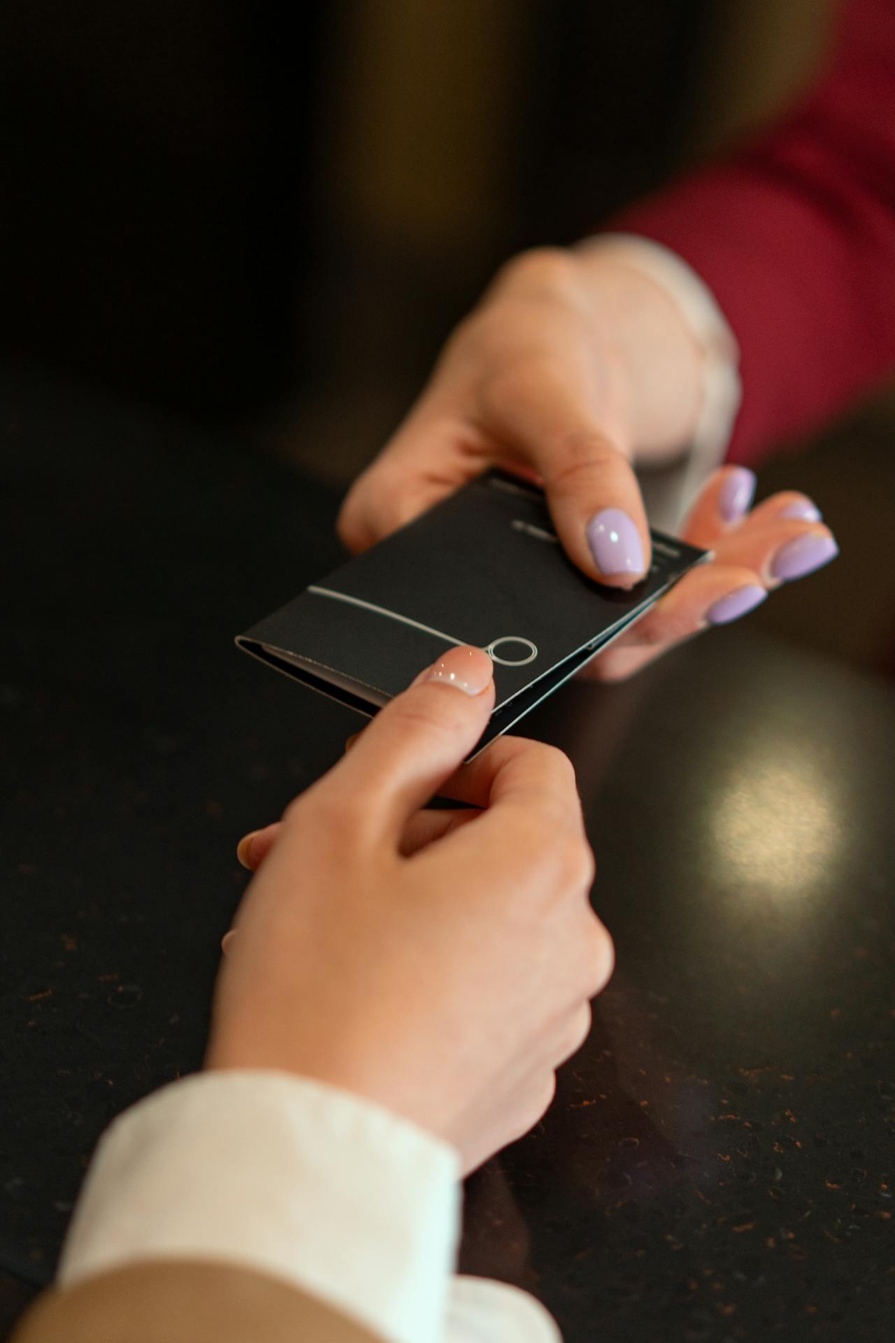 Una mujer entregando una tarjeta a otra mujer | Fuente: Pexels