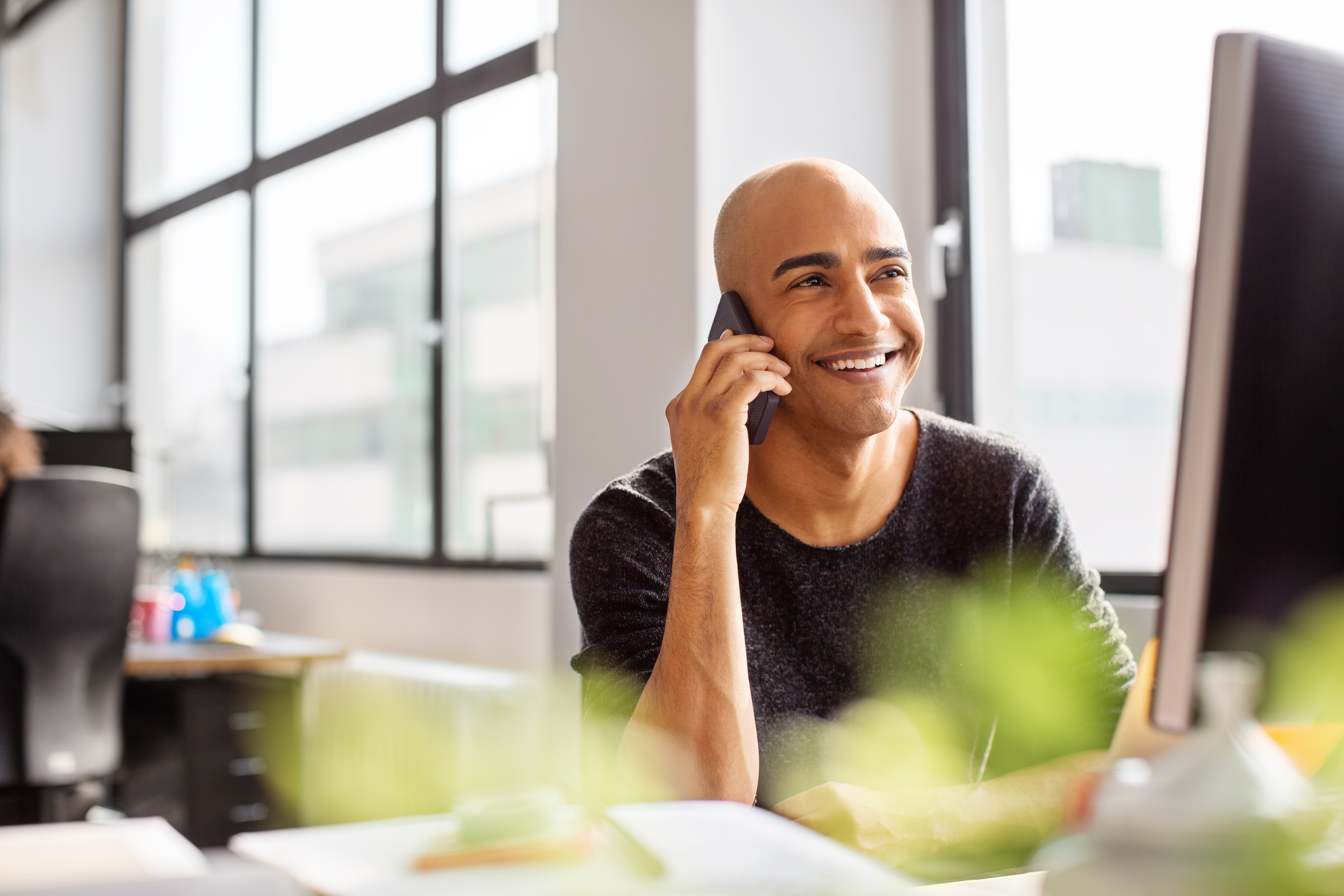 Hombre sonriendo mientras habla por teléfono | Fuente: Getty Images