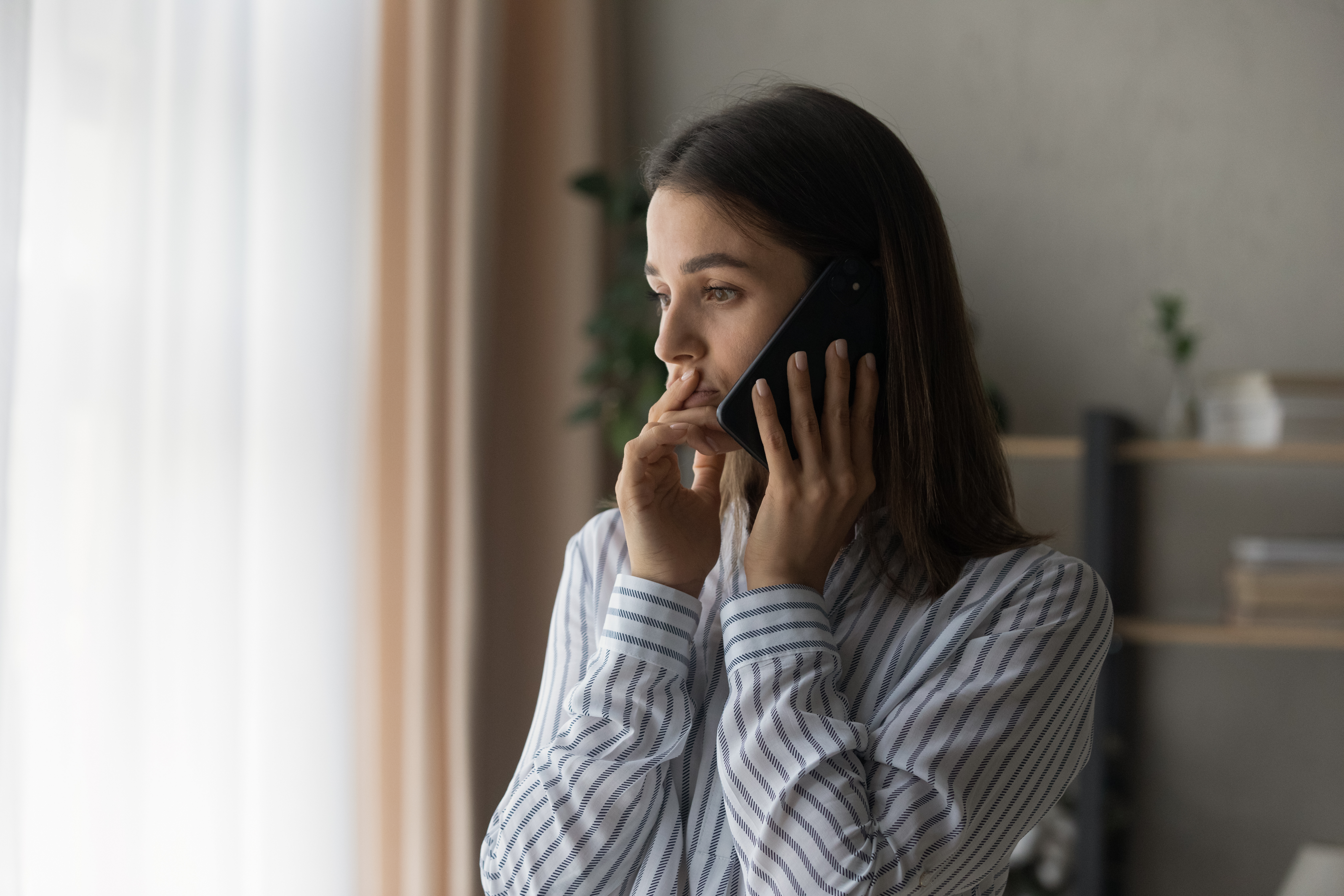 Chica joven al teléfono con cara de preocupación | Fuente: Shutterstock