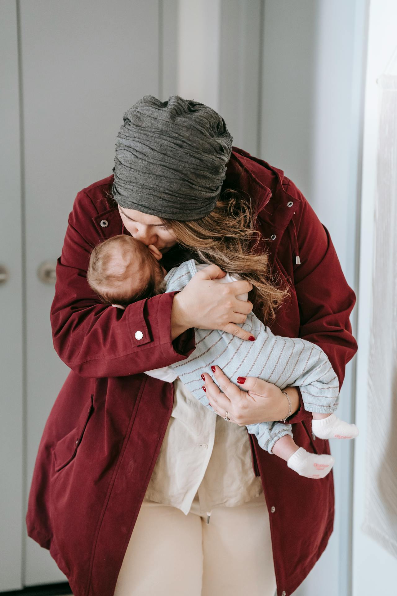 Una madre besando a su bebé en la frente | Fuente: Pexels