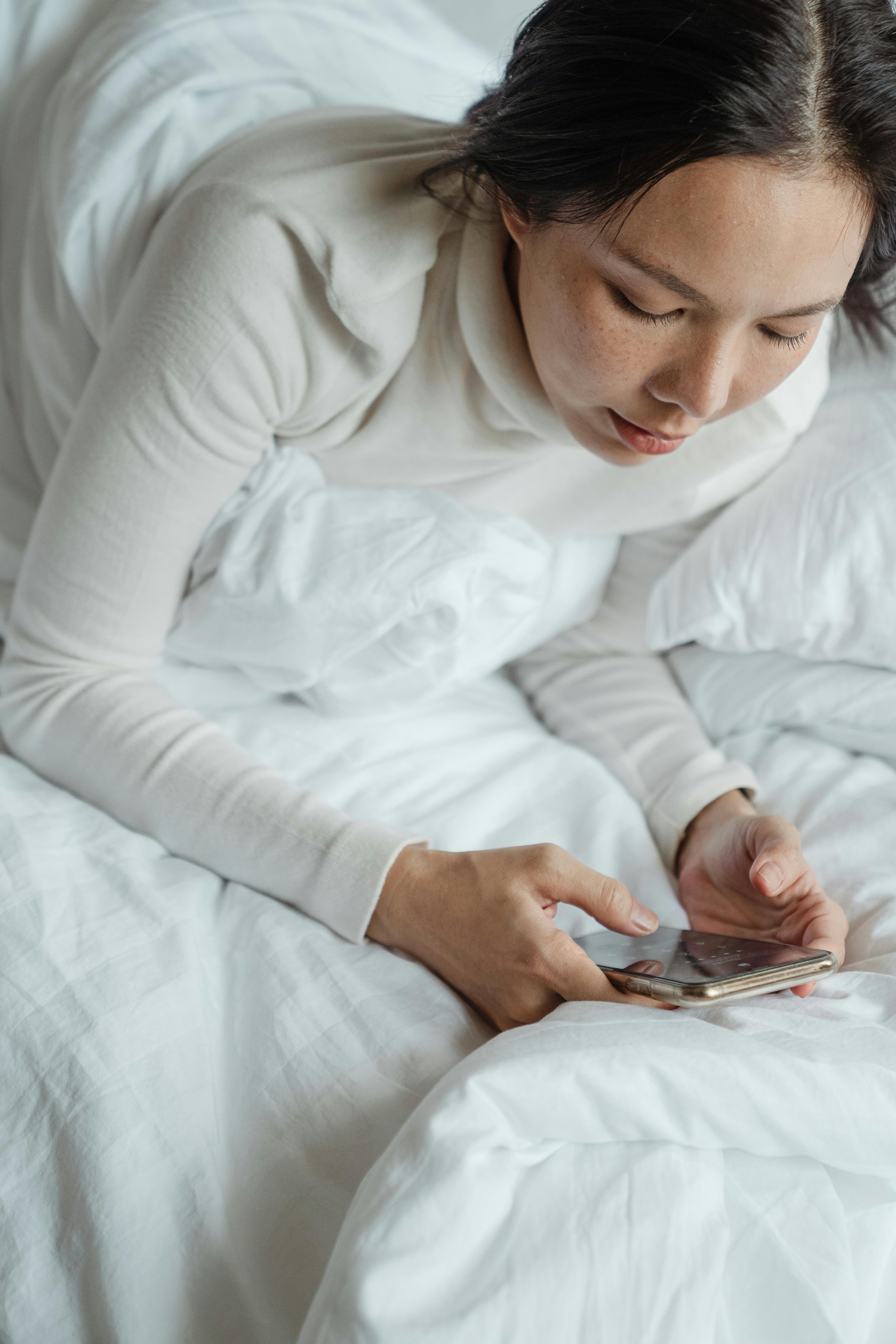 Una donna infelice che guarda il suo telefono | Fonte: Pexels