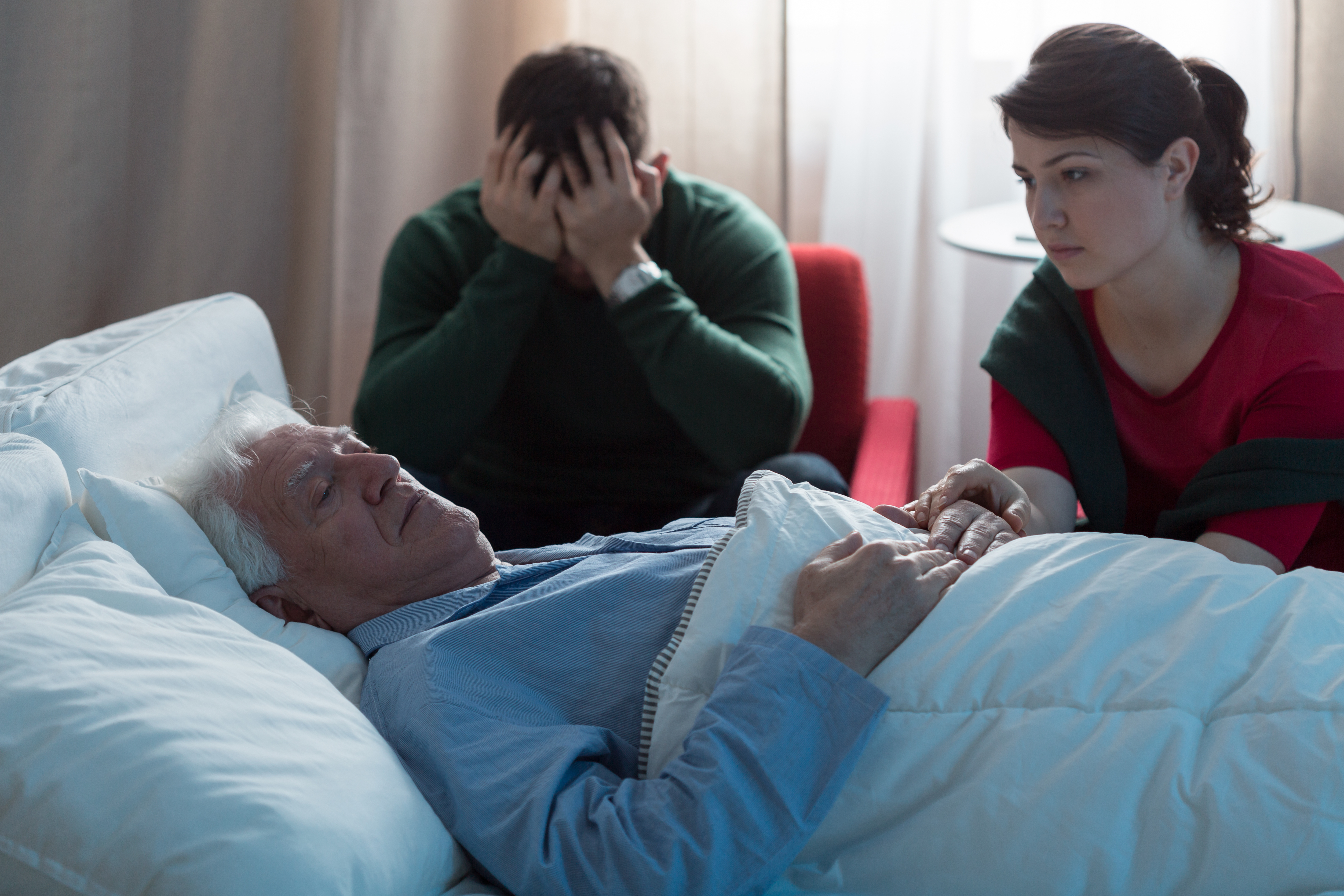 Anciano en el hospital rodeado de su familia | Foto: Shutterstock