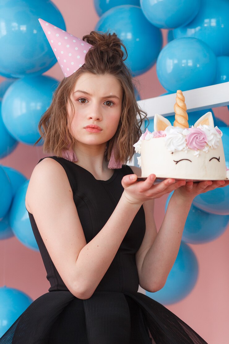 Una cumpleañera con un pastel | Fuente: Freepik