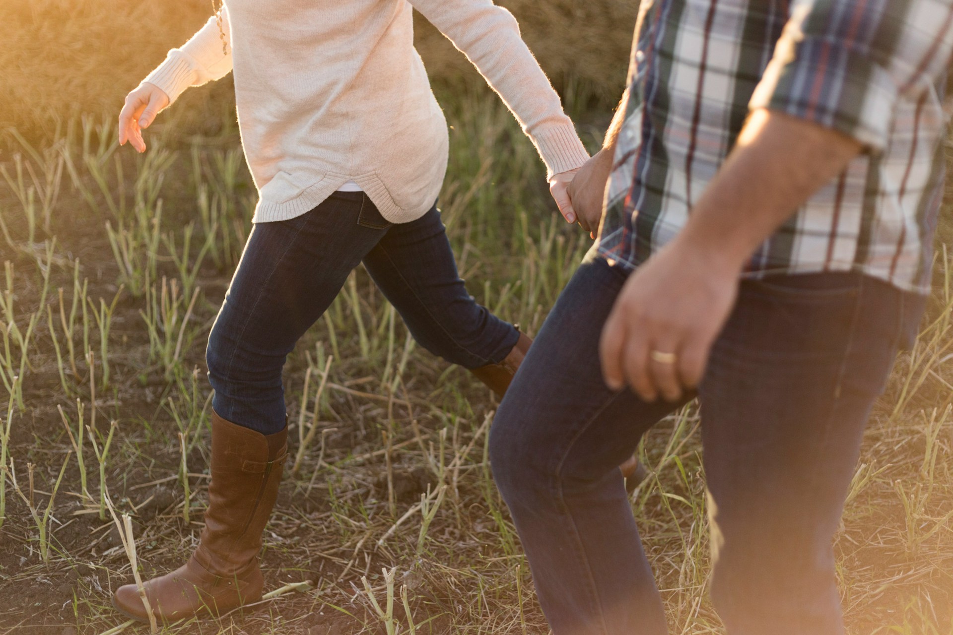 Una pareja cogida de la mano en un campo | Fuente: Unsplash