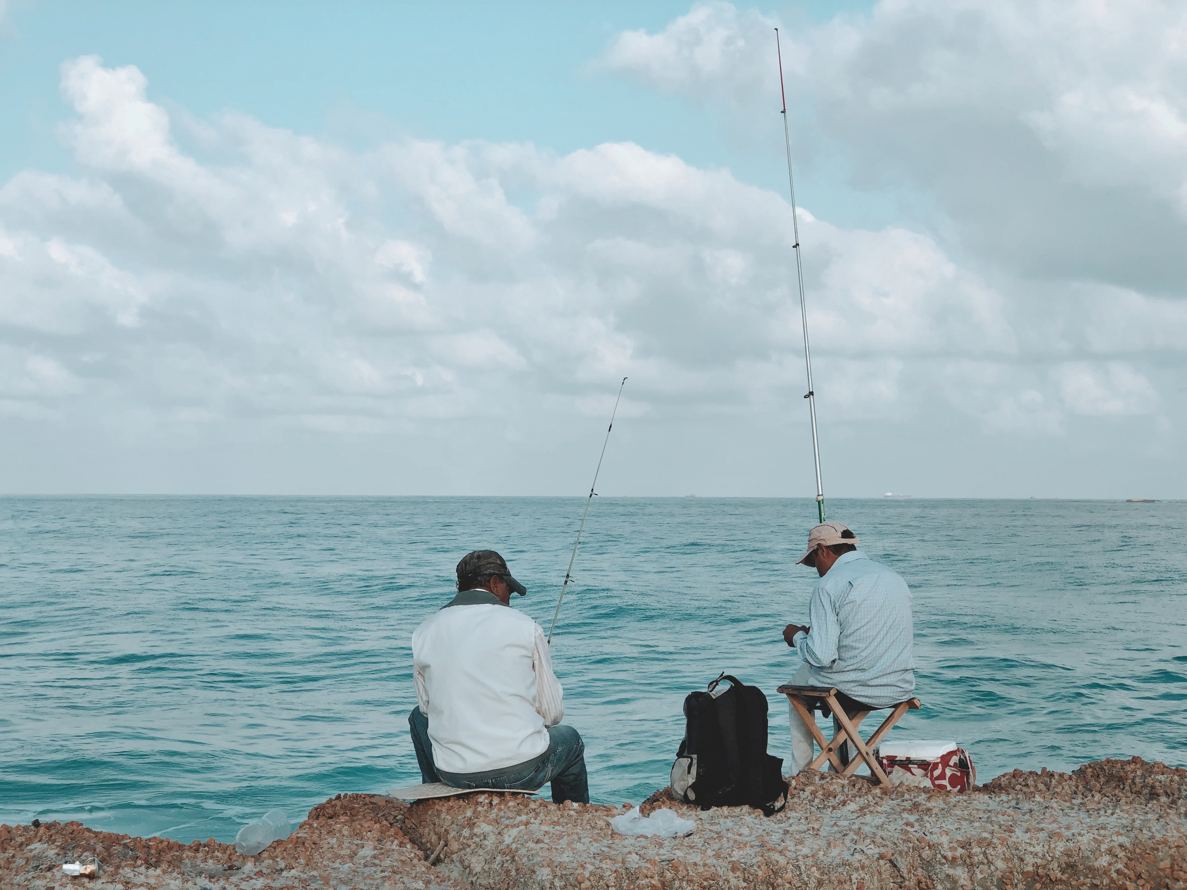 Una par de hombres pescando en la orilla. | Imagen: Unsplash.com  