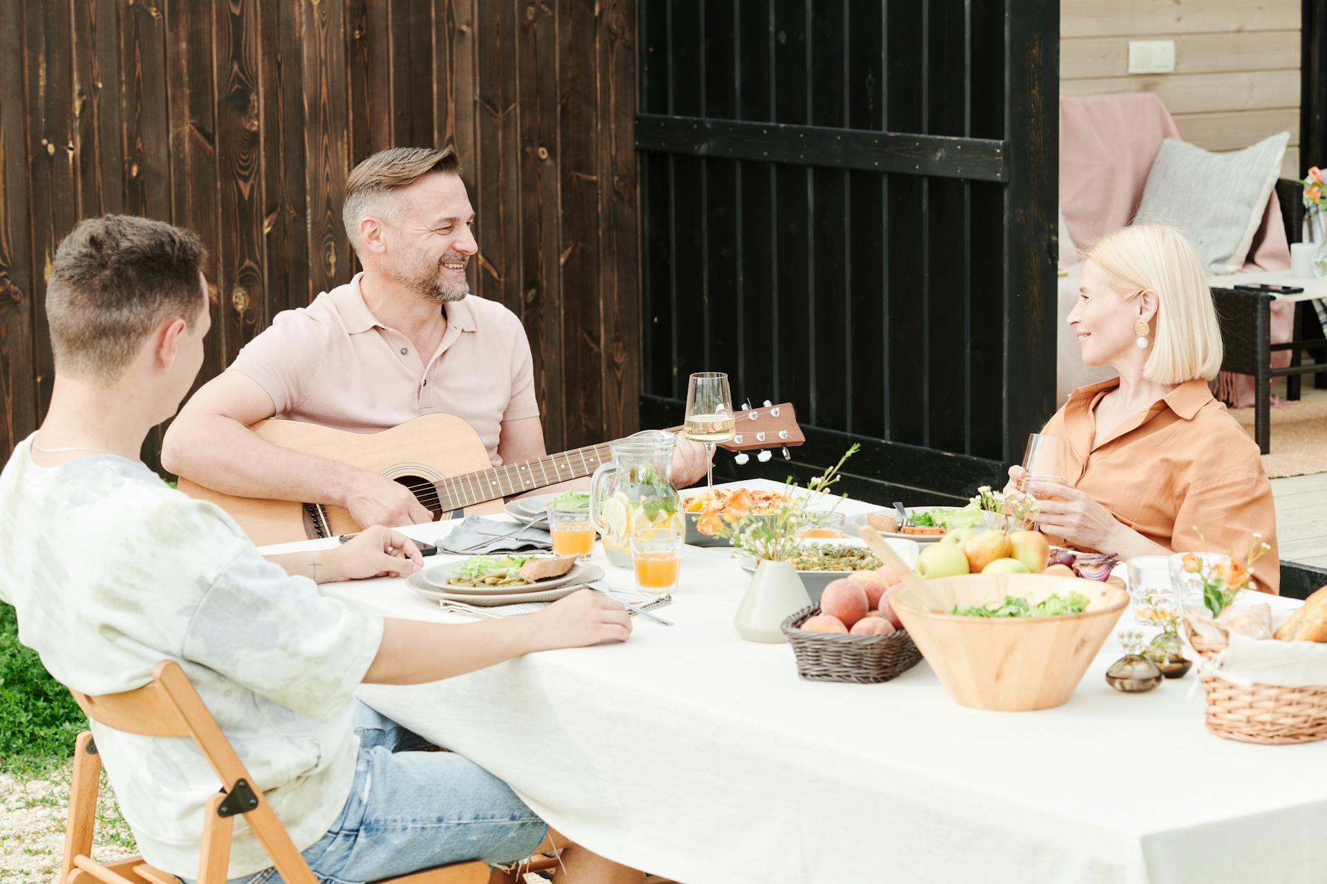 Un hombre tocando la guitarra durante una cena familiar | Fuente: Pexels