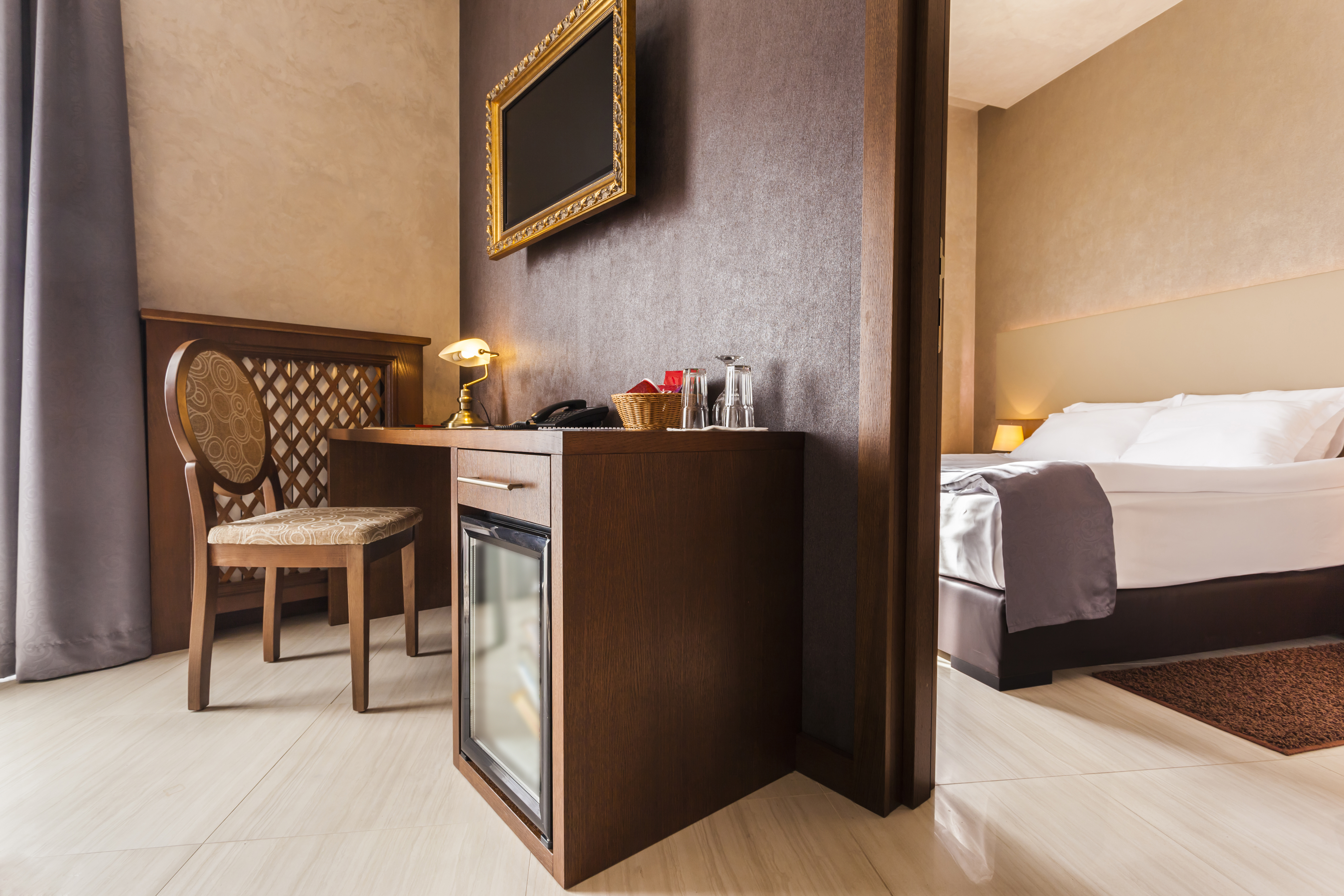 Interior de habitación de hotel de lujo con minibar en tonos marrones. | Fuente: Shutterstock