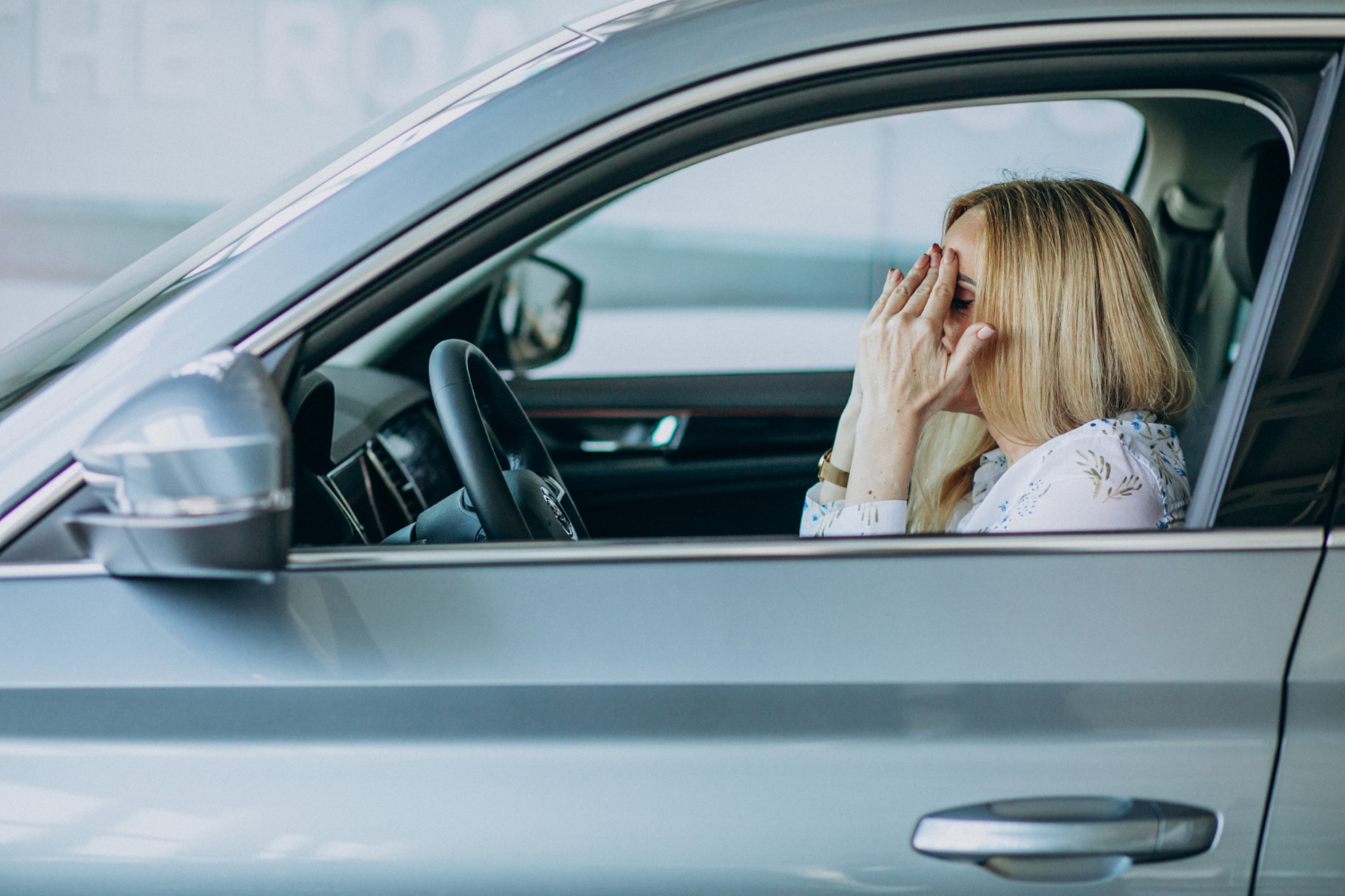 Una mujer mayor deprimida sentada en el automóvil | Fuente: Freepik