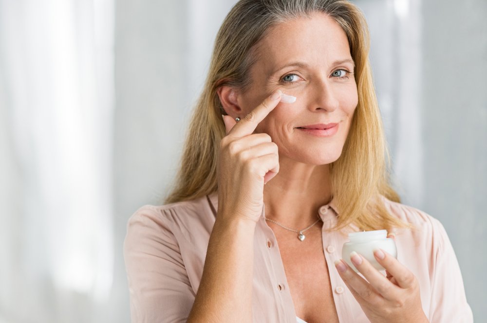 Mujer aplicando crema hidratante en el contorno de sus ojos. | Foto: Shutterstock
