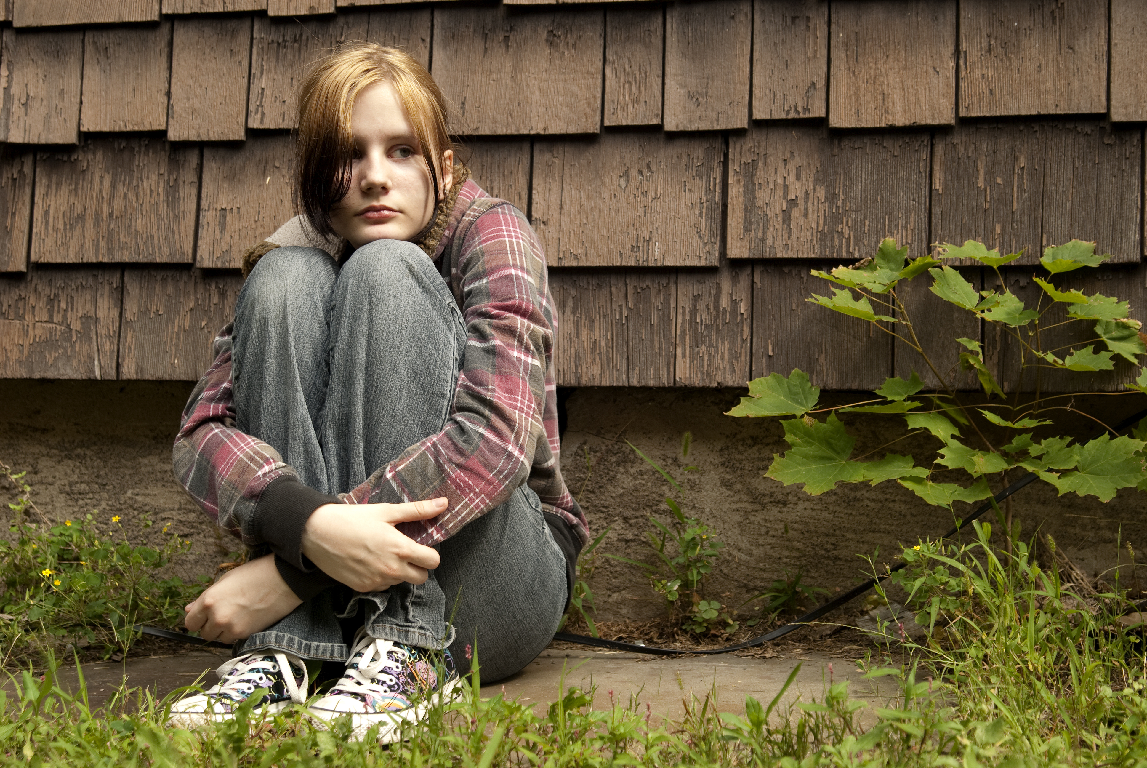 Una chica triste sentada en el suelo | Foto: Shutterstock