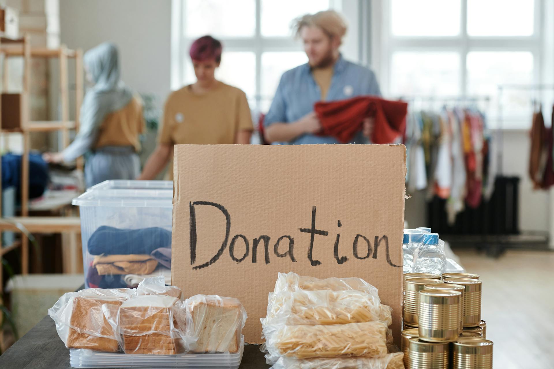 Cajas de comida colocadas junto a una inscripción de cartón en la que se lee "Donación" | Fuente: Pexels