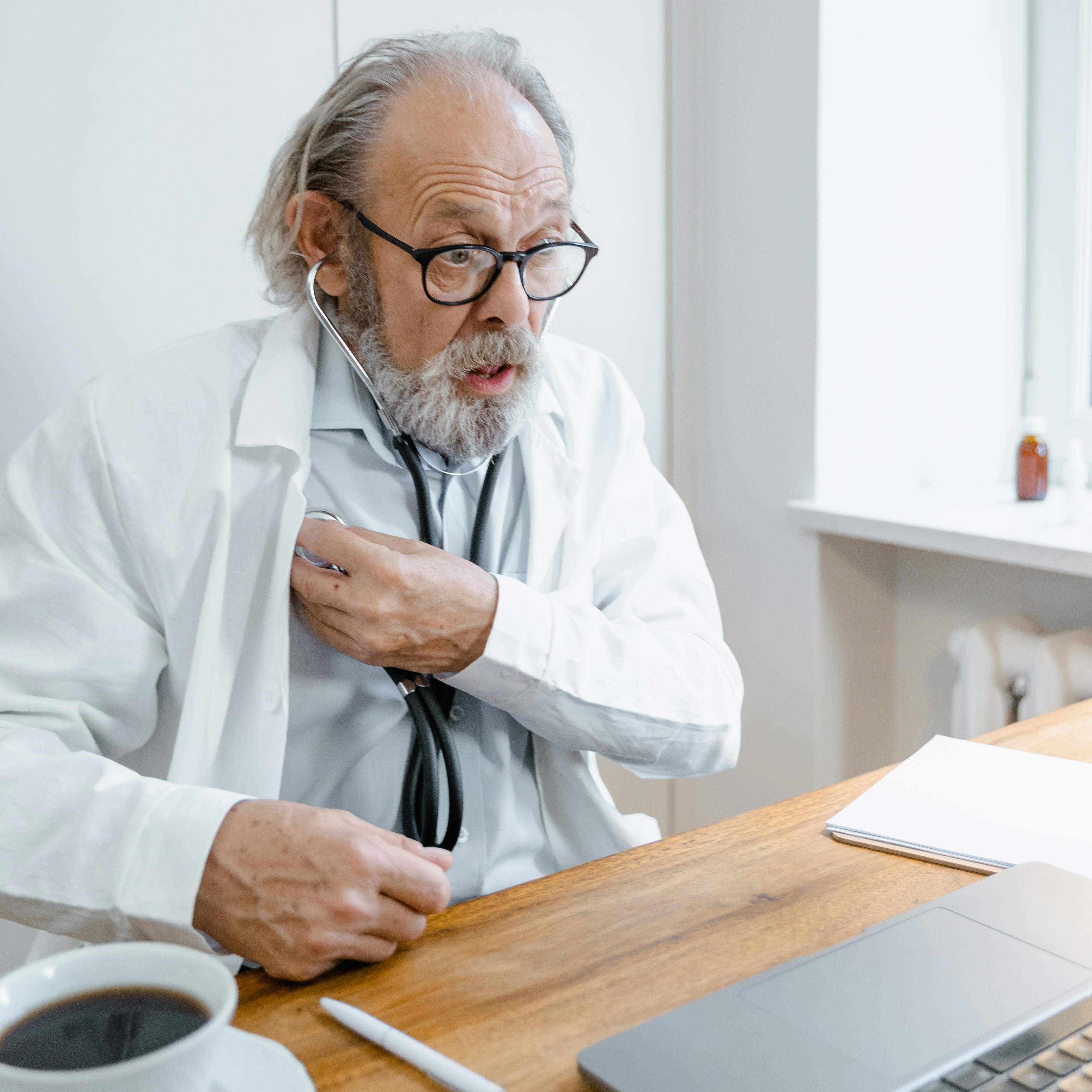 Un médico reaccionando a algo mientras está sentado en su mesa | Fuente: Pexels