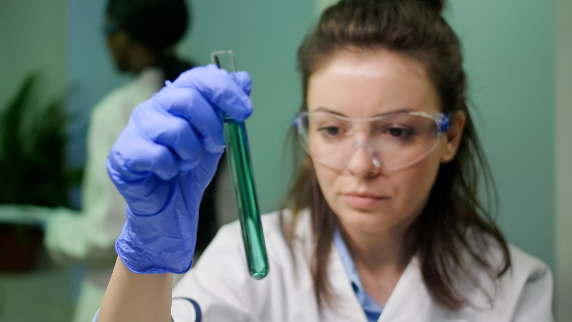 Una persona sujetando un tubo de ensayo en un laboratorio | Fuente: Freepik