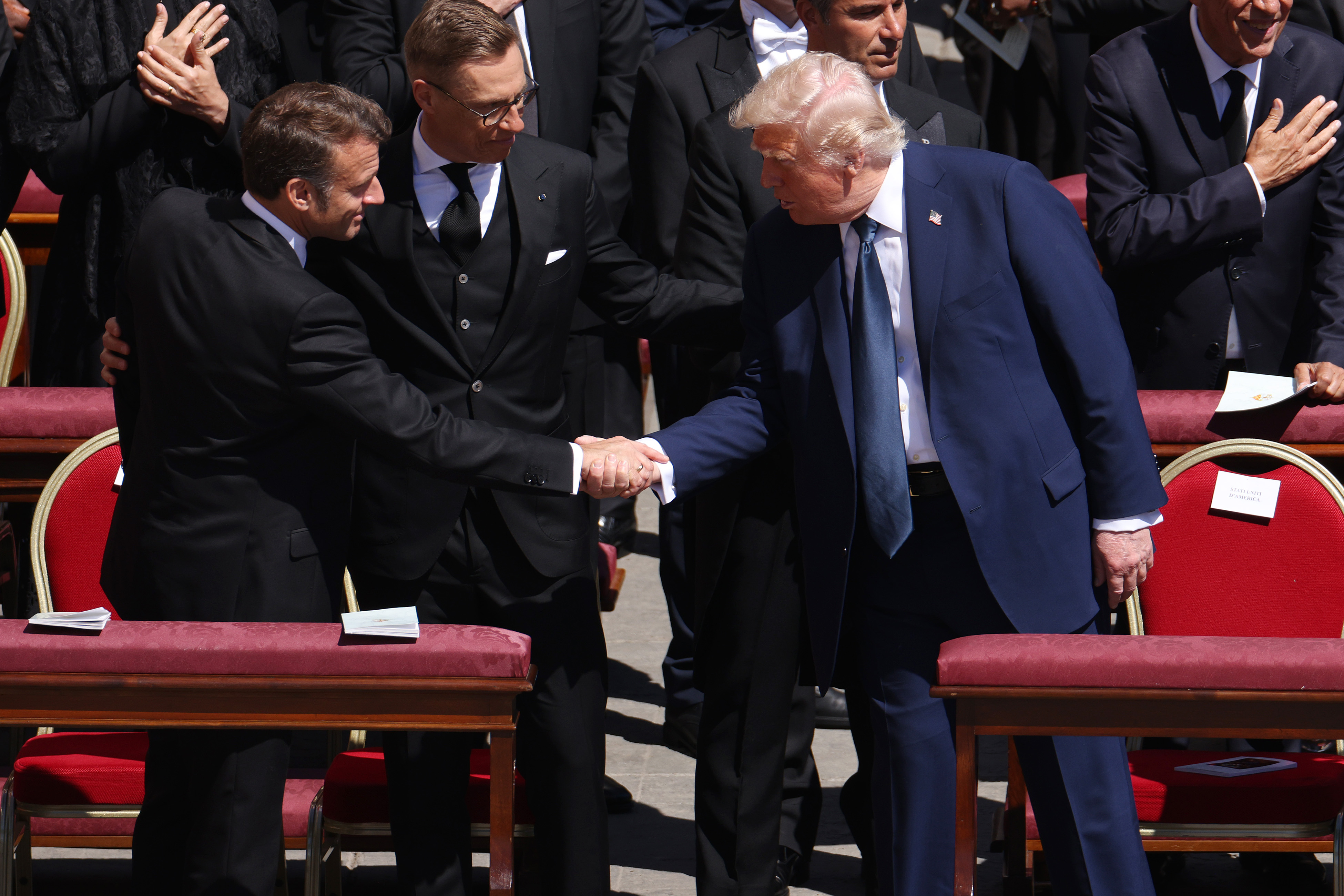 El presidente de Francia, Emmanuel Macron, y el presidente de EE.UU., Donald Trump, se dan un apretón de manos mientras el presidente de Finlandia, Alexander Stubb, se interpone entre ambos | Fuente: Getty Images