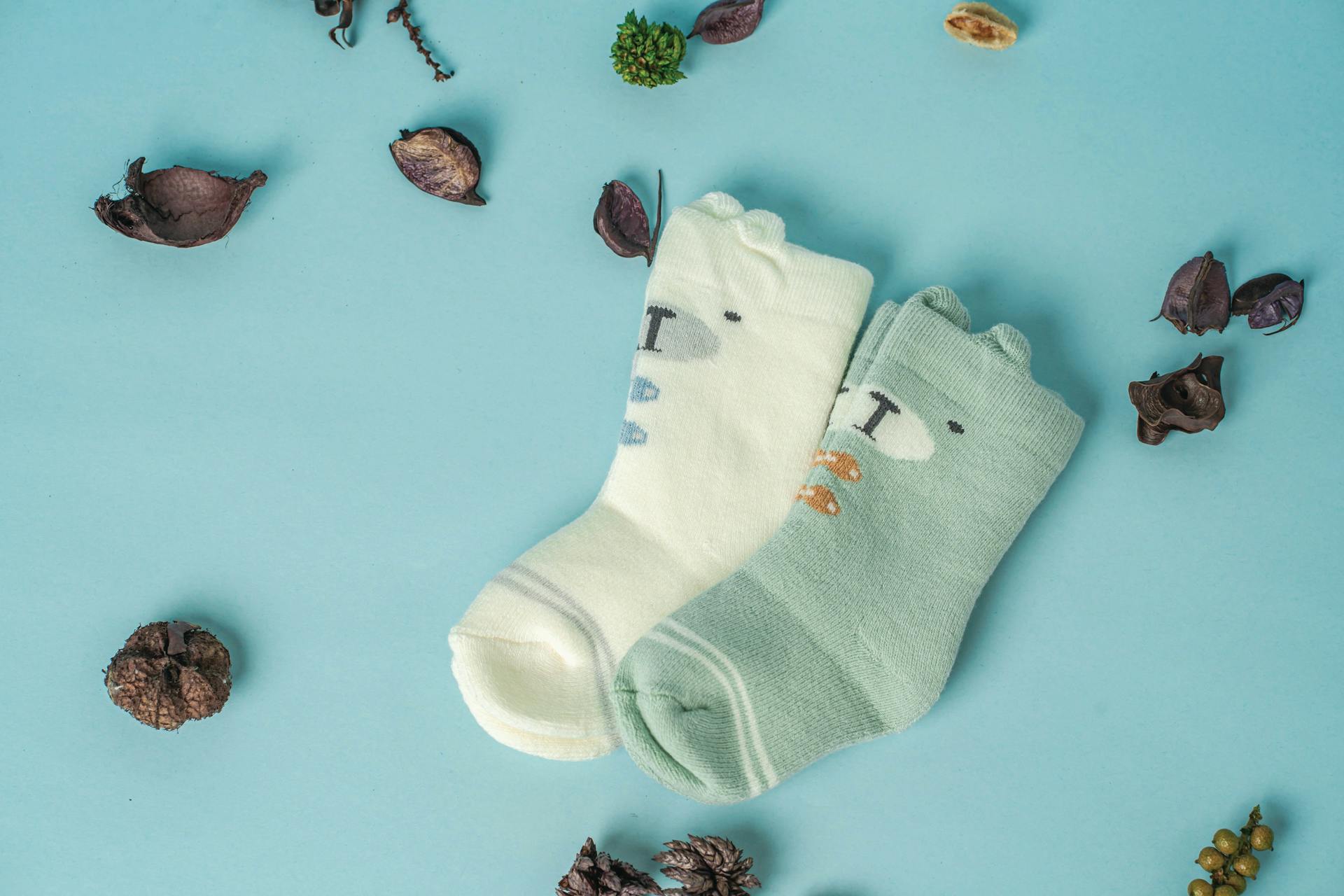 Primer plano de unos calcetines de bebé sobre una superficie azul | Fuente: Pexels