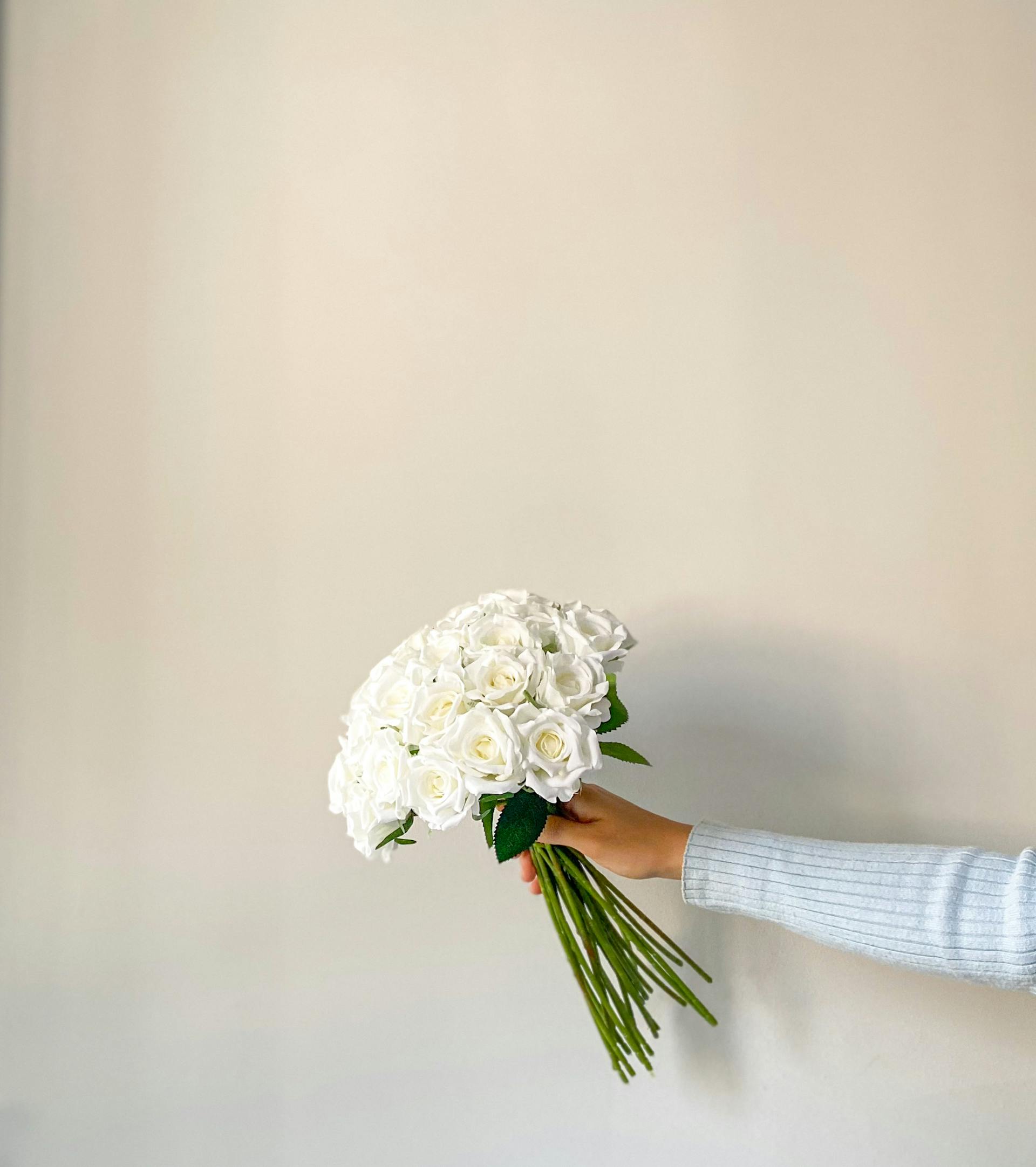 Una mujer con un ramo de rosas blancas | Fuente: Pexels