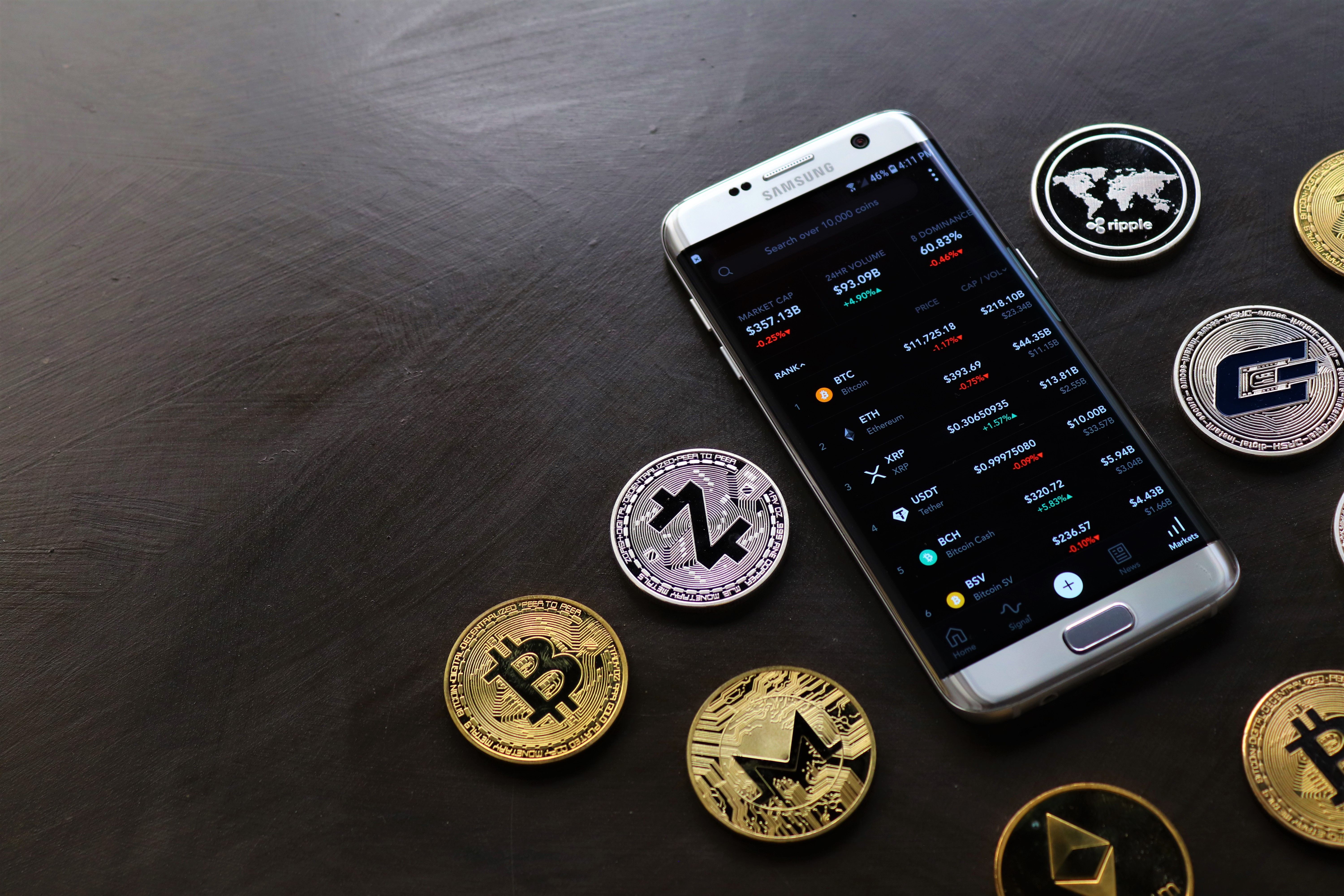 Una colección de monedas y un smartphone | Fuente: Pexels