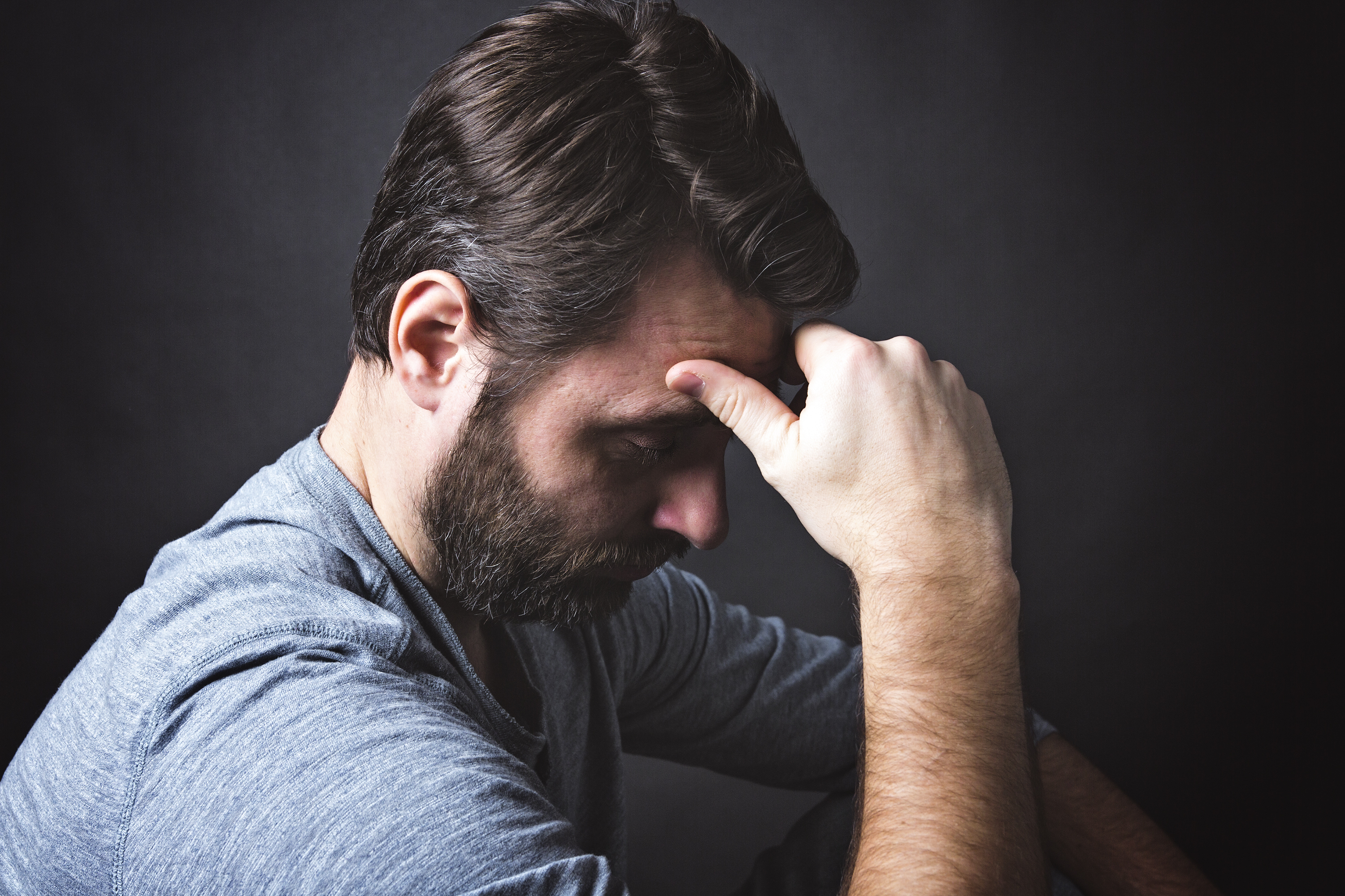 Un hombre sentado en la oscuridad y contemplando | Fuente: Shutterstock