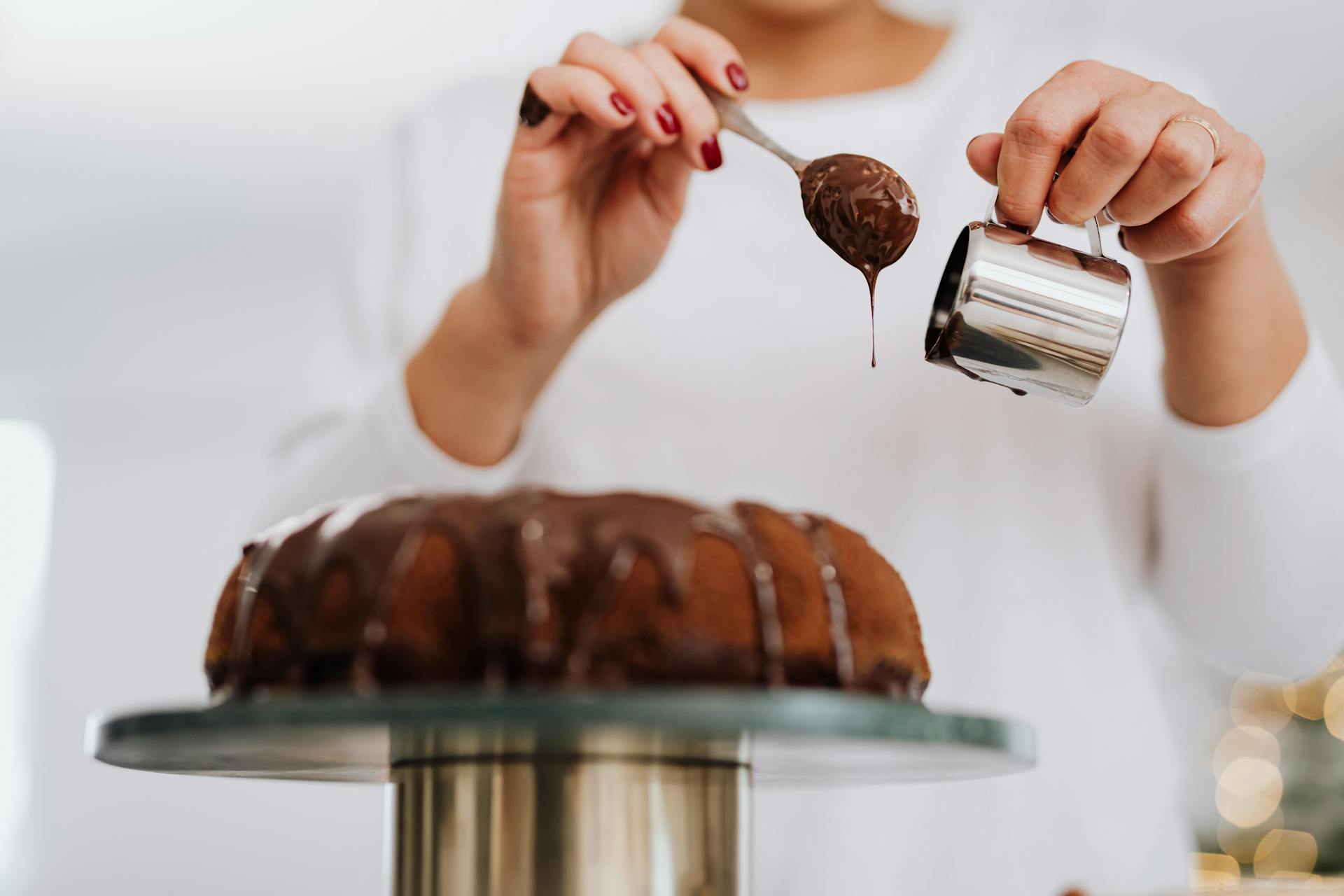 Una mujer decorando un pastel con chocolate | Fuente: Pexels