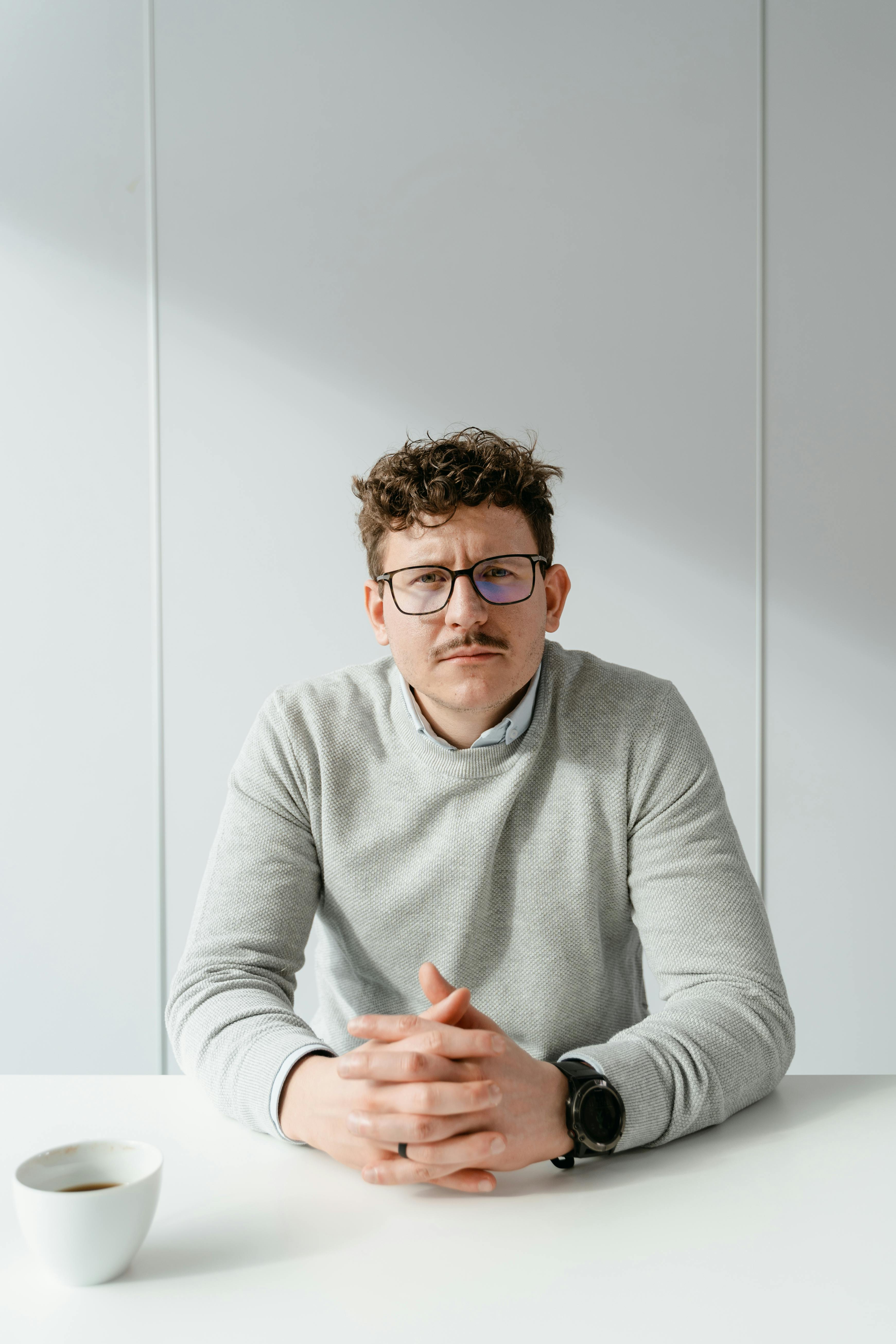 Un hombre serio sentado en una mesa | Fuente: Pexels