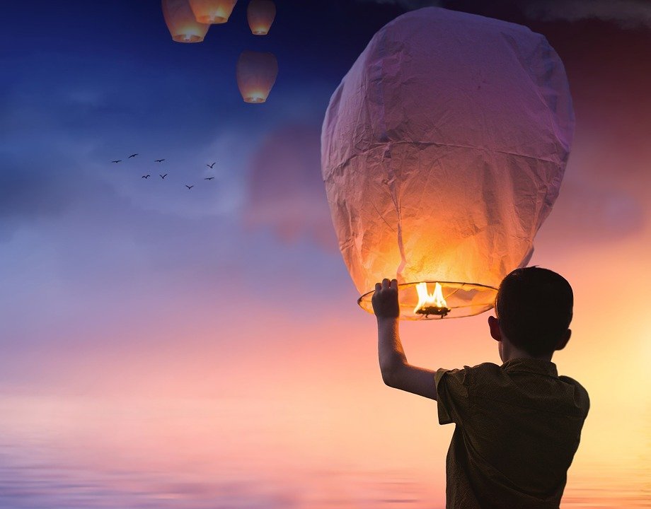 Persona elevando globo de deseos / Imagen tomada de: Pixabay