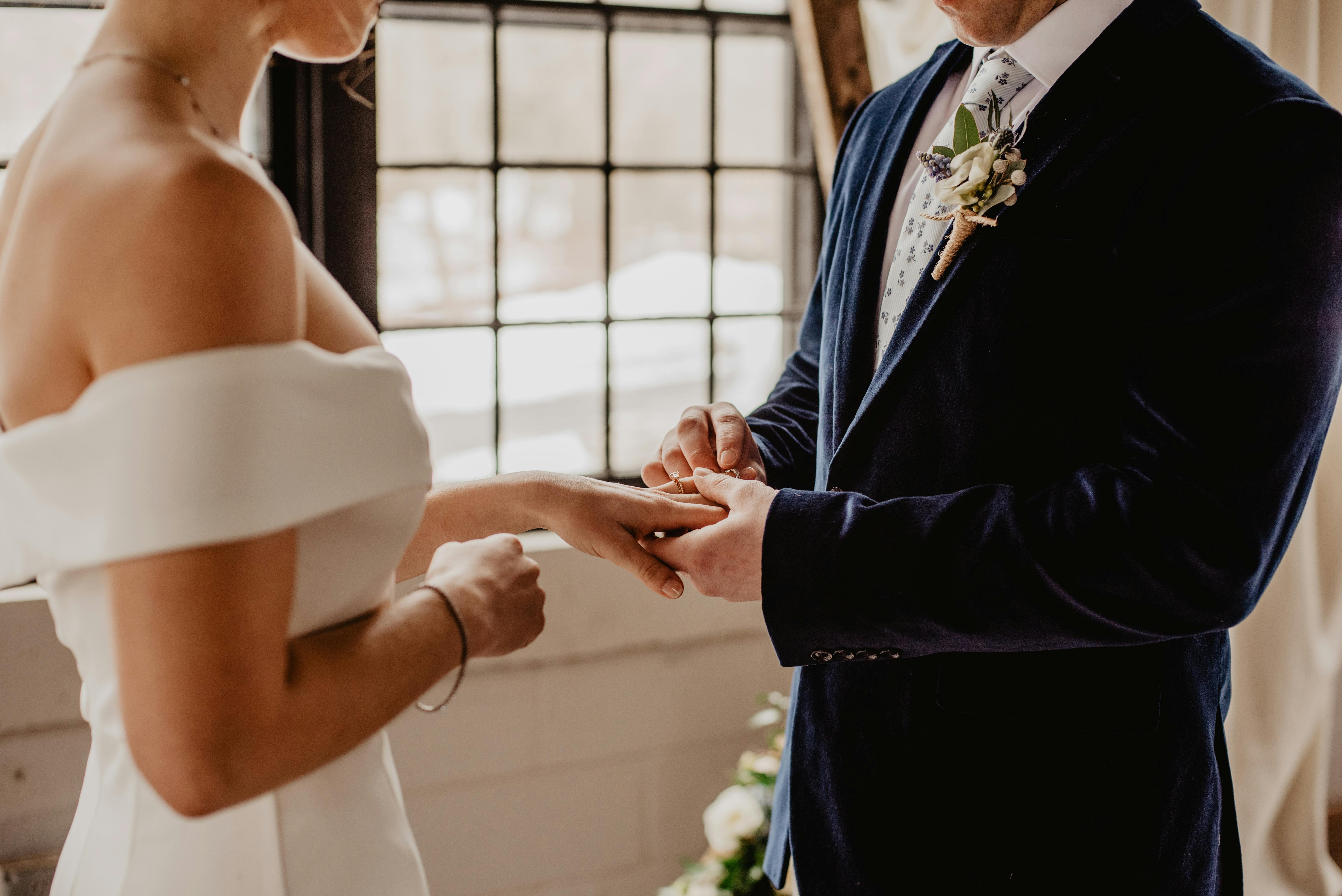 Una novia y un novio intercambiando anillos | Fuente: Pexels