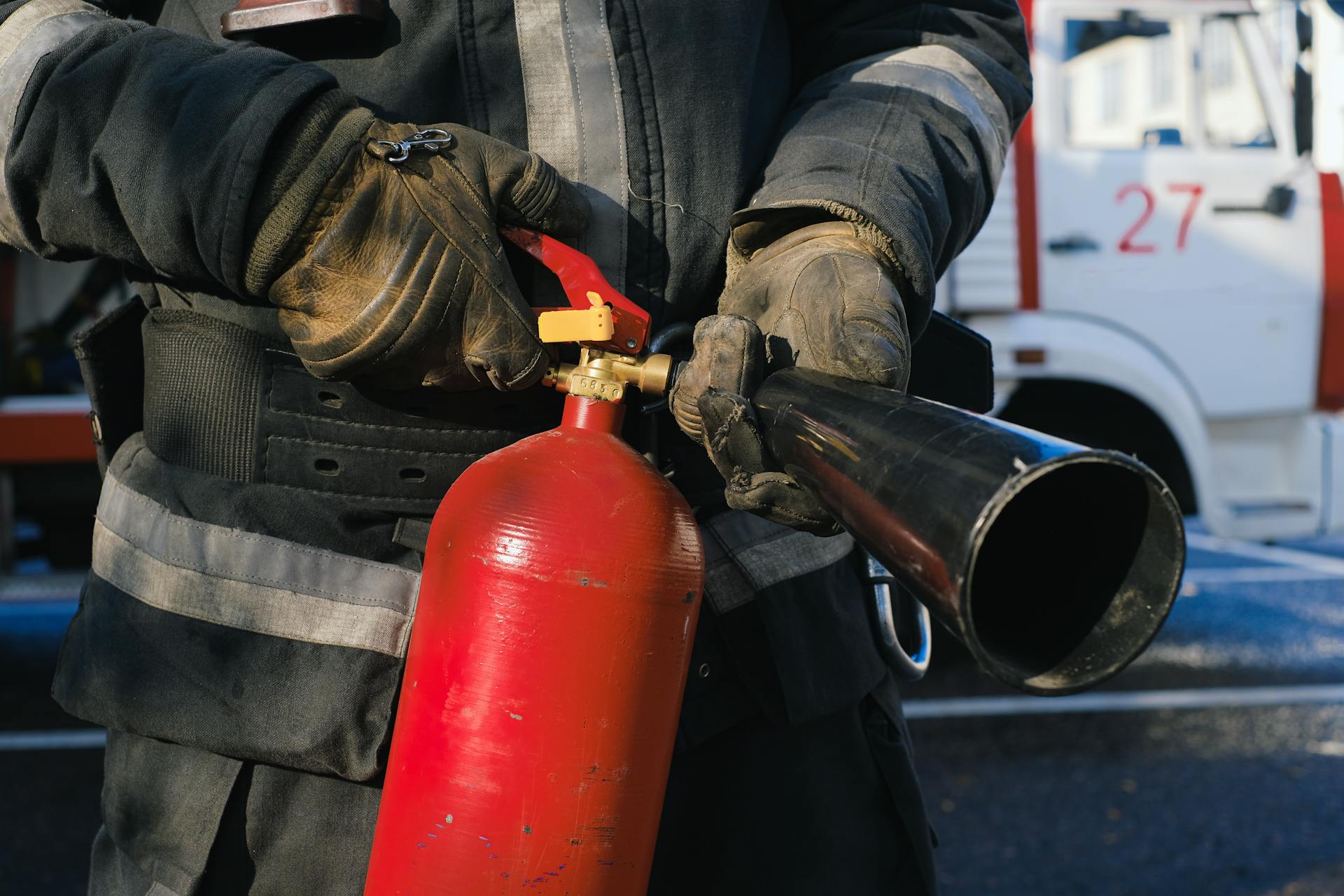 Un bombero sujetando un extintor | Fuente: Pexels