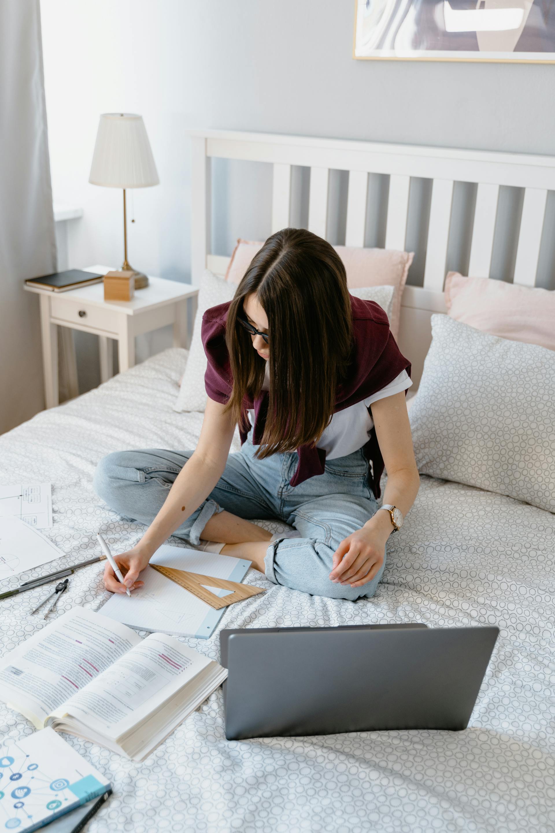 Una mujer estudia sentada en la cama | Fuente: Pexels