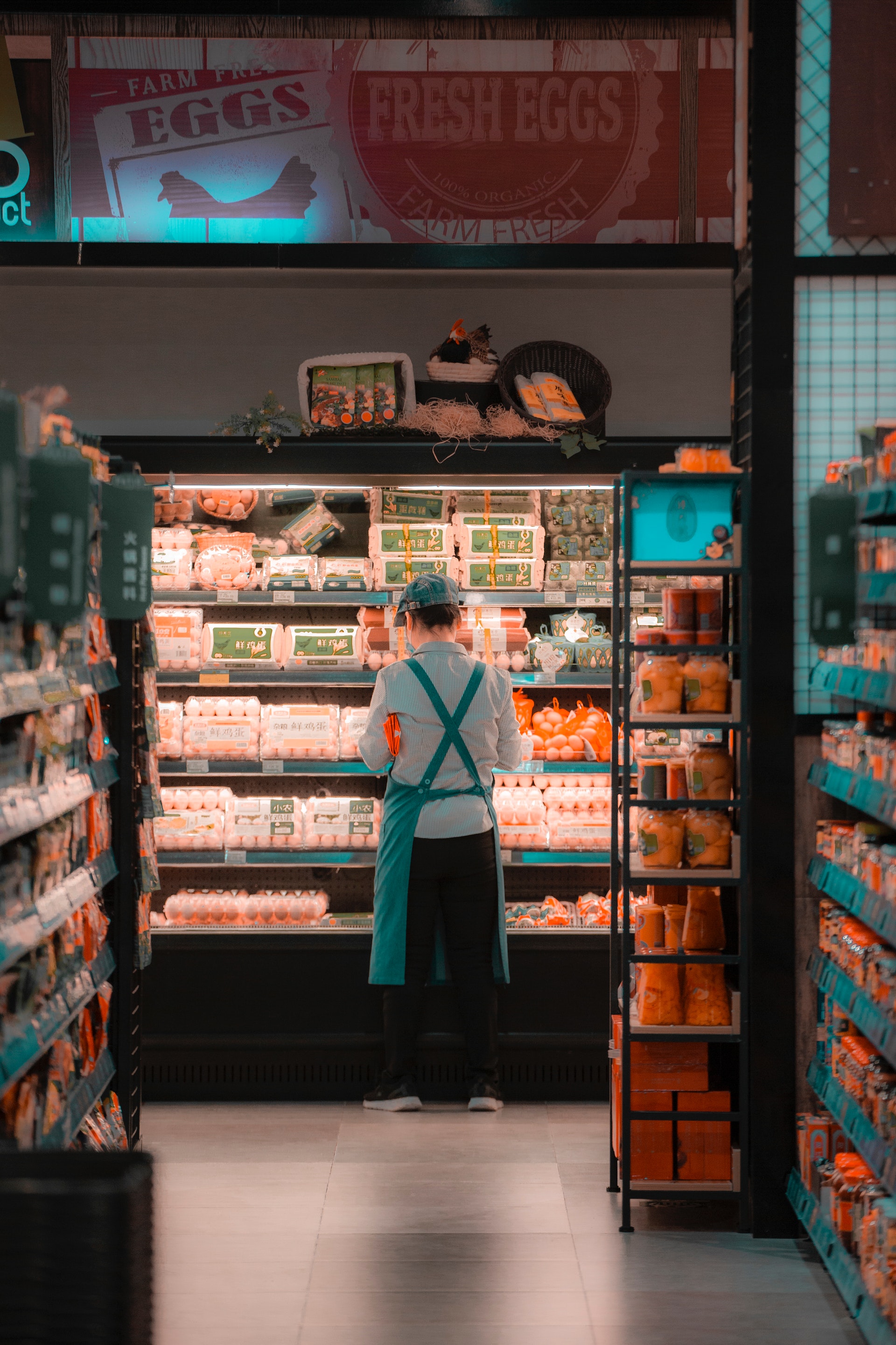 Un empleado de supermercado cerca de la nevera | Fuente: Pexels