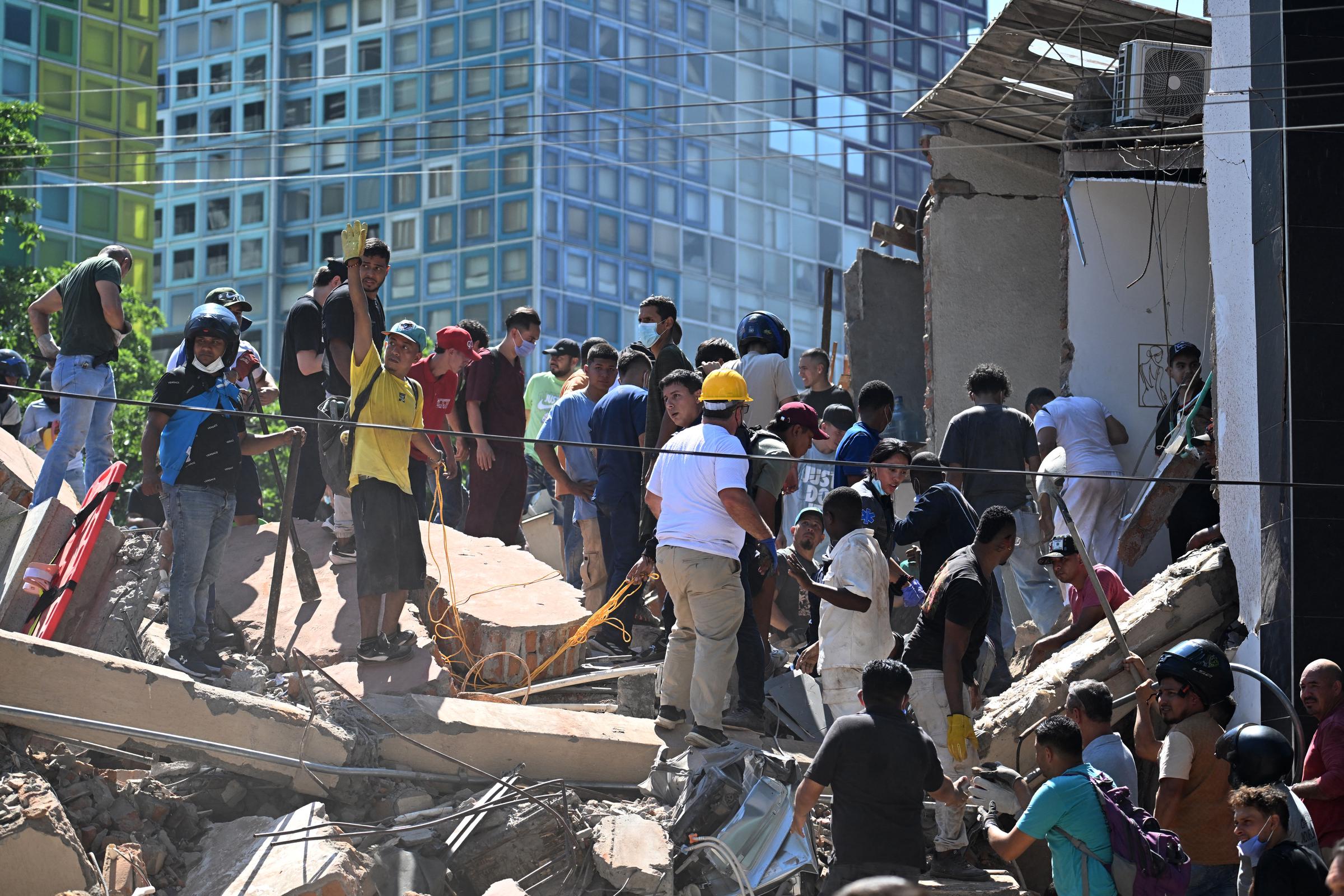 Personas buscan supervivientes entre los escombros de un edificio derrumbado tras un terremoto en Cali, Colombia, el 10 de agosto de 2026. | Fuente: Getty Images