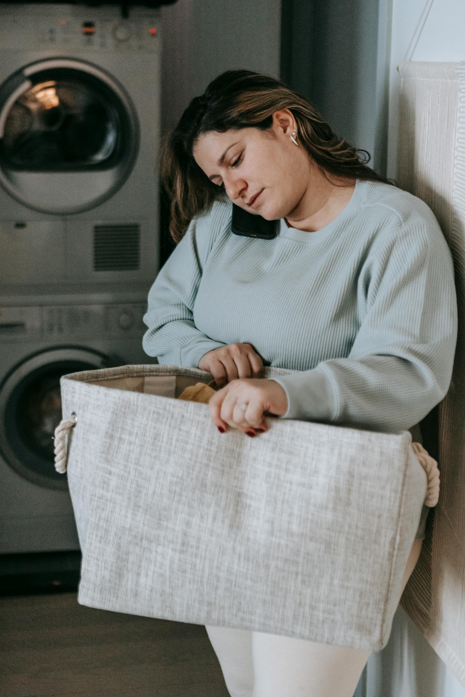 Una mujer sujetando un cesto de la ropa sucia | Fuente: Pexels