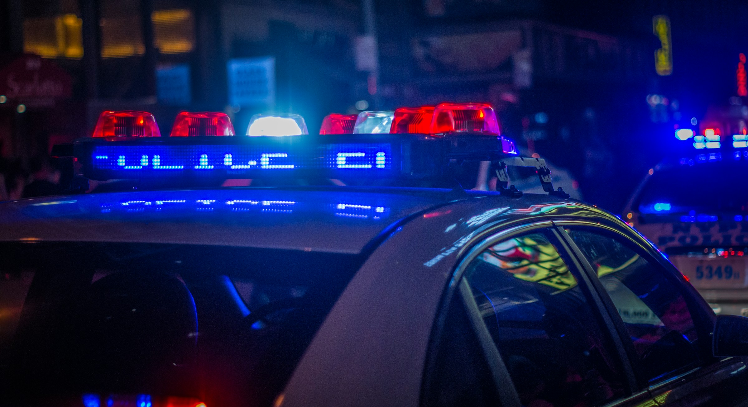 Primer plano de coches de policía en la calle por la noche | Fuente: Unsplash