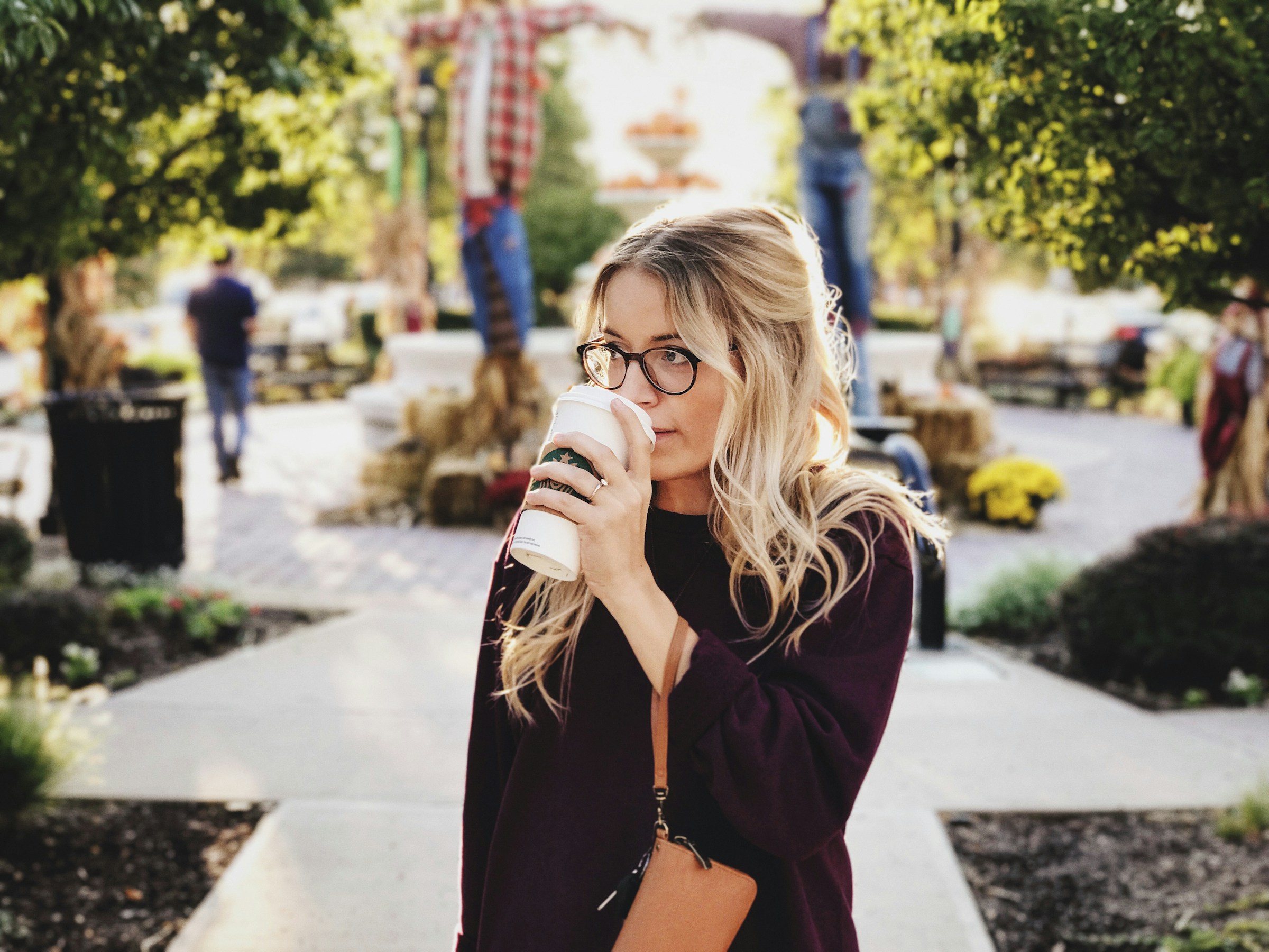 Una mujer bebiendo café mientras camina al aire libre | Fuente: Unsplash