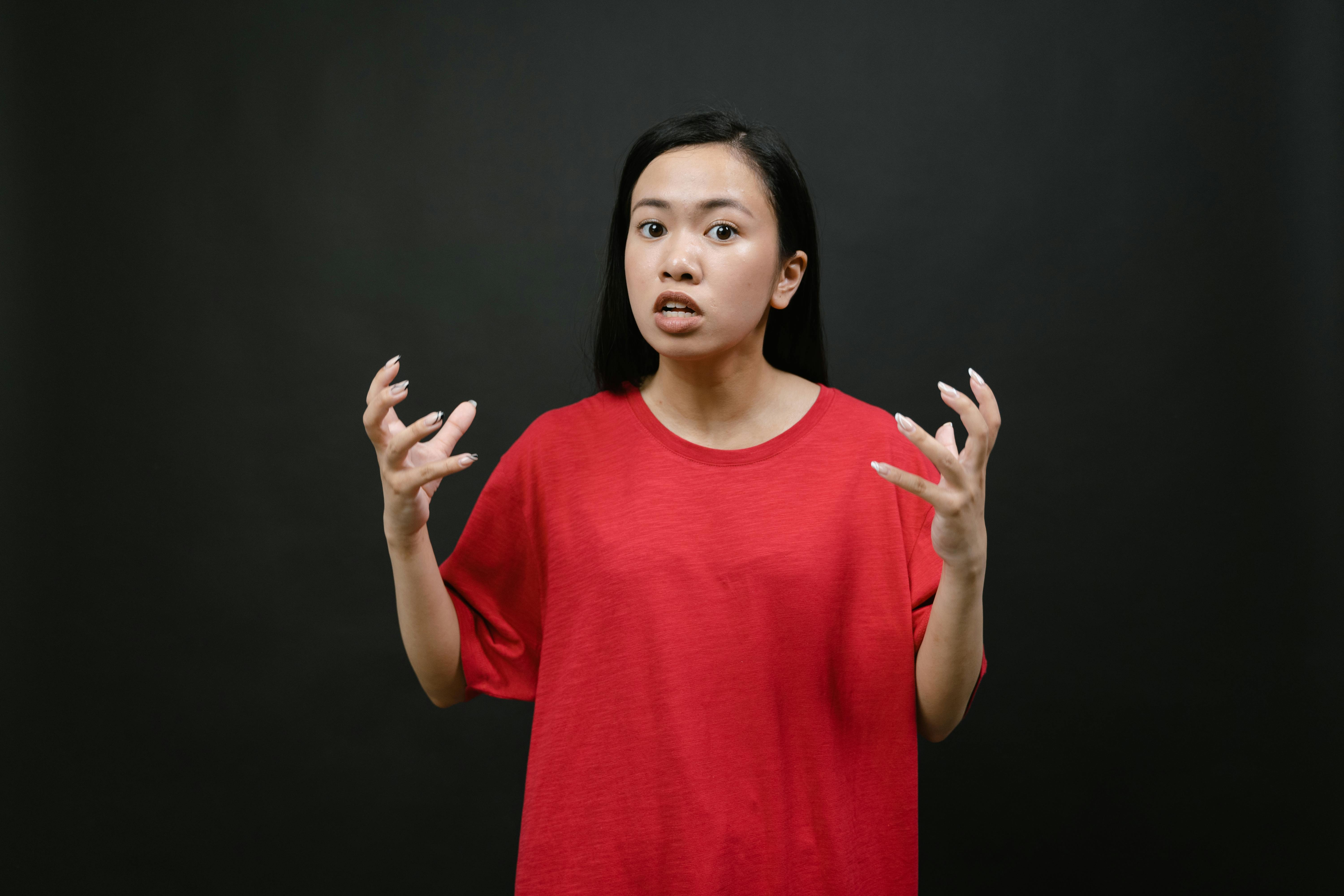 Una mujer enfadada con una camiseta roja | Fuente: Pexels