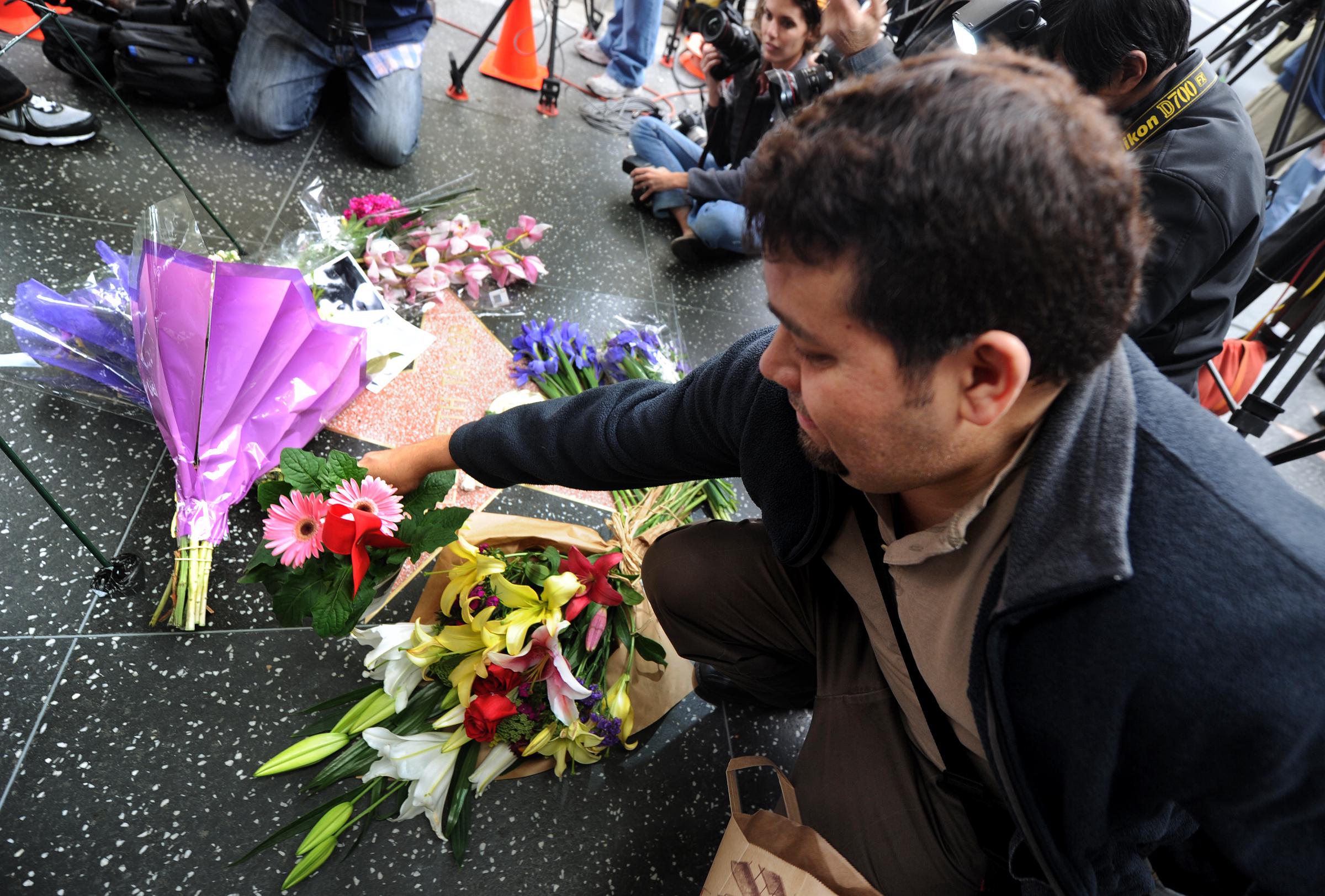 Una fan deposita flores en la estrella de la actriz en el Paseo de la Fama de Hollywood en Hollywood, California, el 23 de marzo de 2011 | Fuente: Getty Images