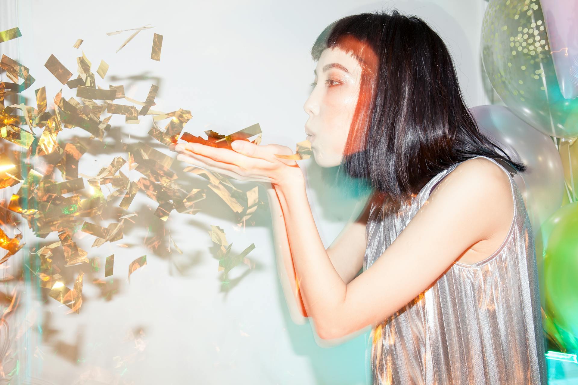 Una mujer sopla confeti al aire | Fuente: Pexels